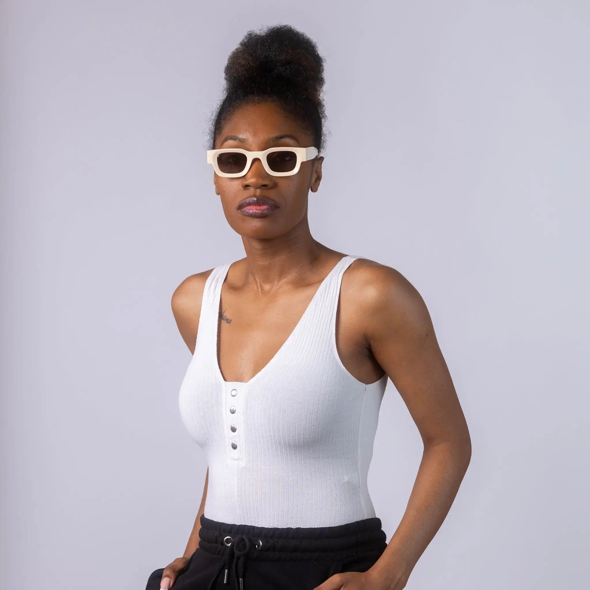 A female model wearing Exposure Sunglasses polarized sunglasses with beige frames and brown lenses, posing against a white background.