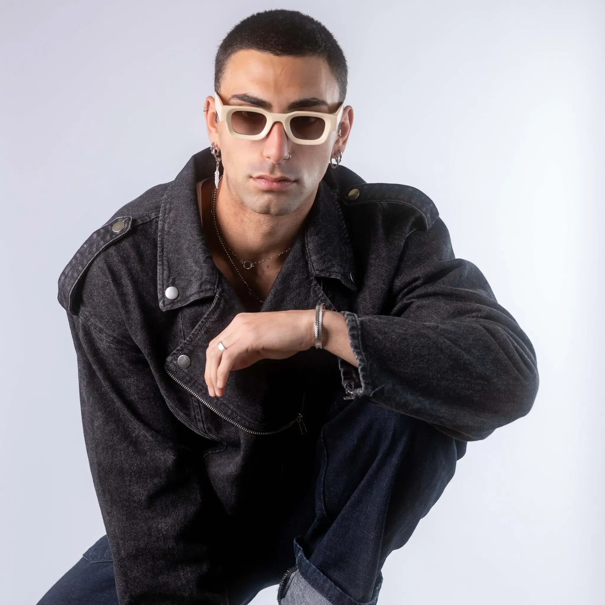 A male model wearing Exposure Sunglasses polarized sunglasses with beige frames and brown lenses, posing against a white background.