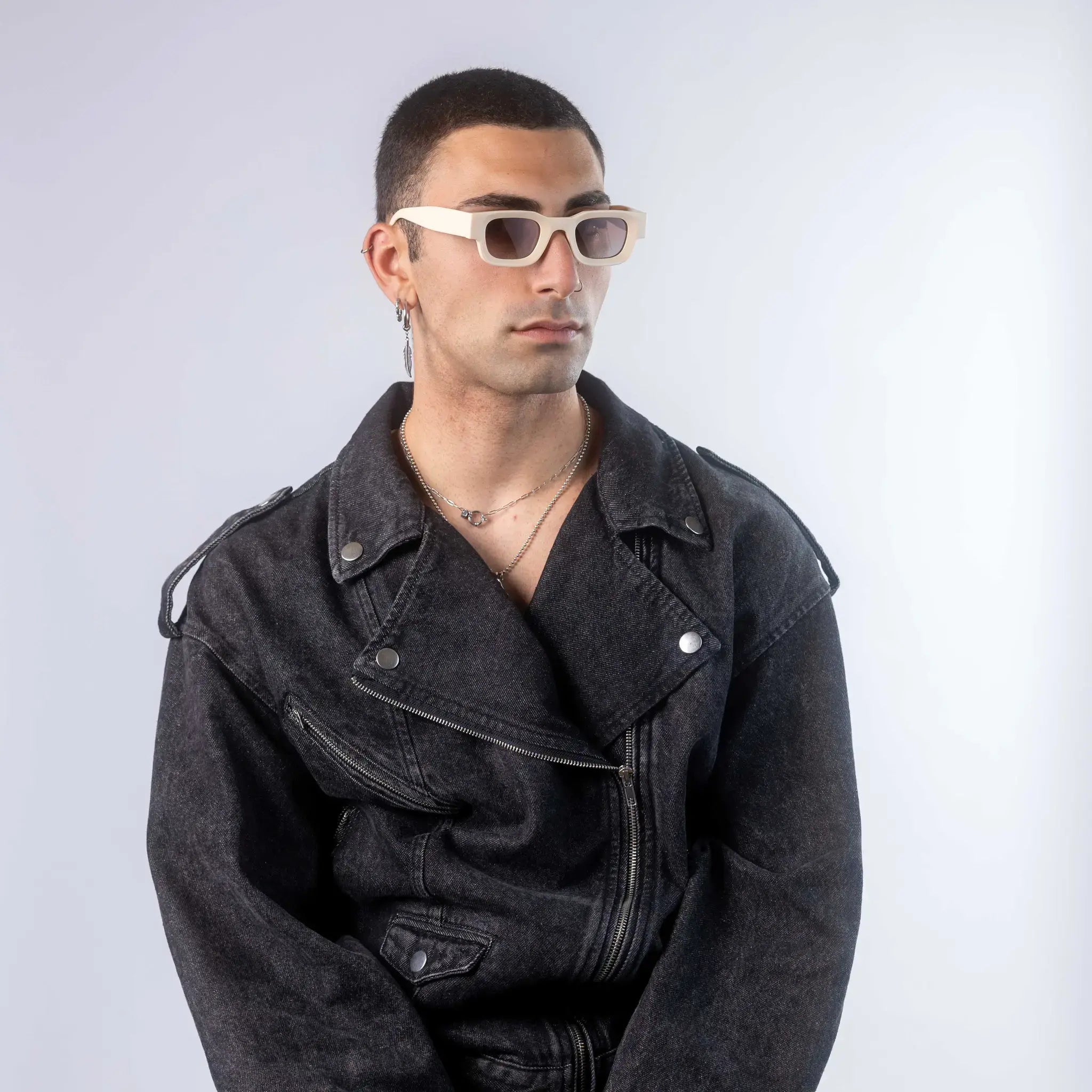 A male model wearing Exposure Sunglasses polarized sunglasses with beige frames and brown lenses, posing against a white background.