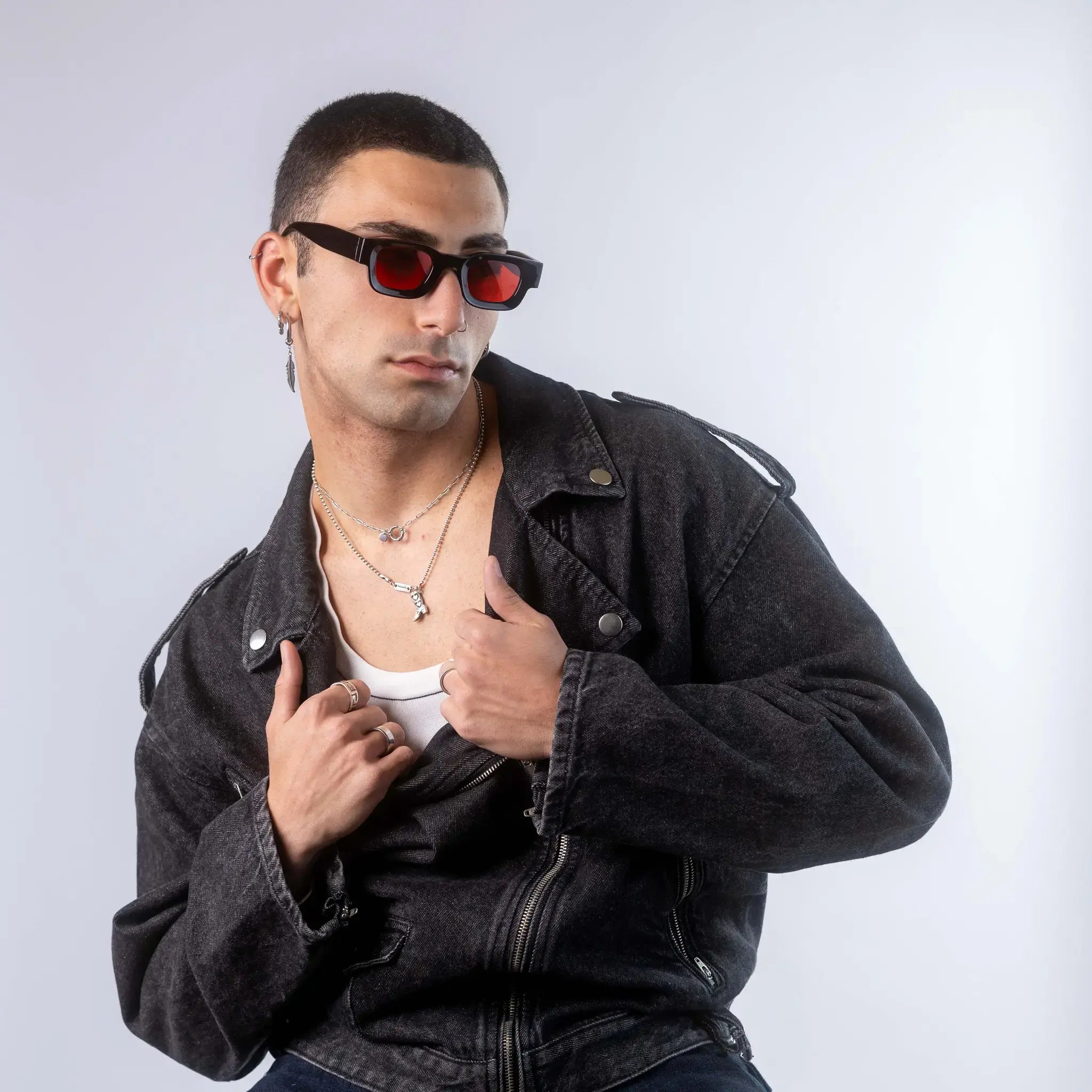 A male model wearing Exposure Sunglasses polarized sunglasses with black frames and red lenses, posing against a white background.