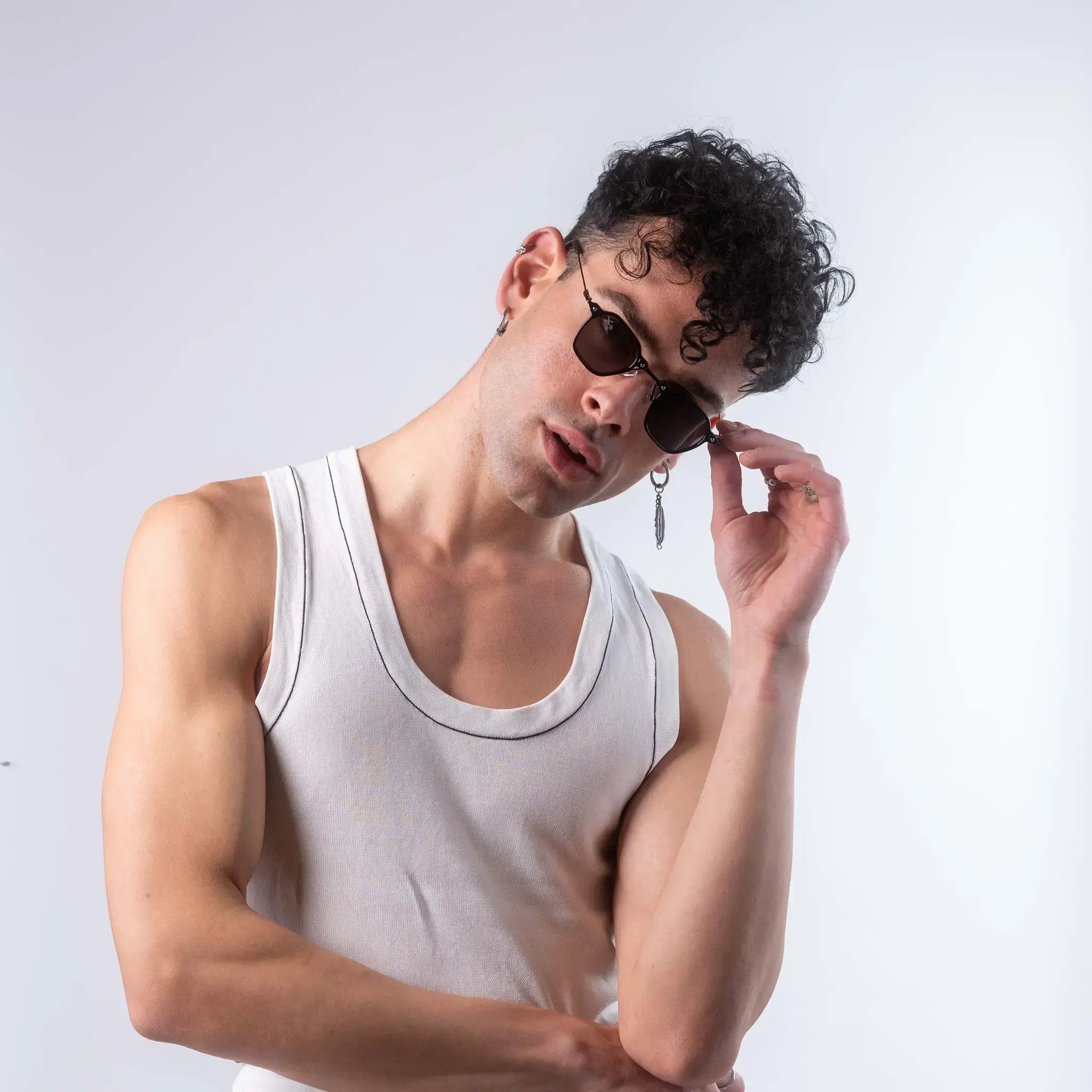 A male model wearing Exposure Sunglasses polarized sunglasses with black frames and black lenses, posing against a white background.