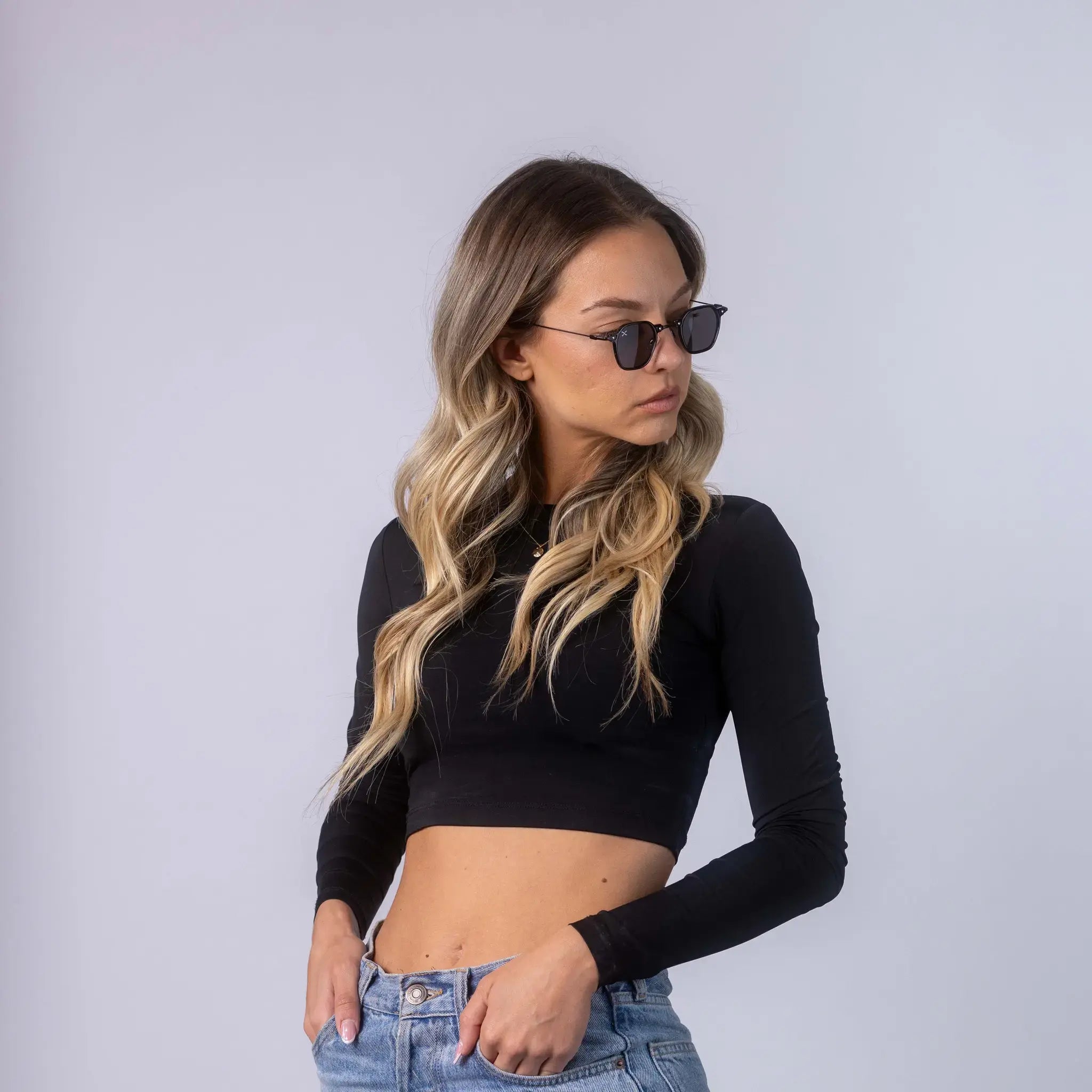 A female model wearing Exposure Sunglasses polarized sunglasses with black frames and black lenses, posing against a white background.