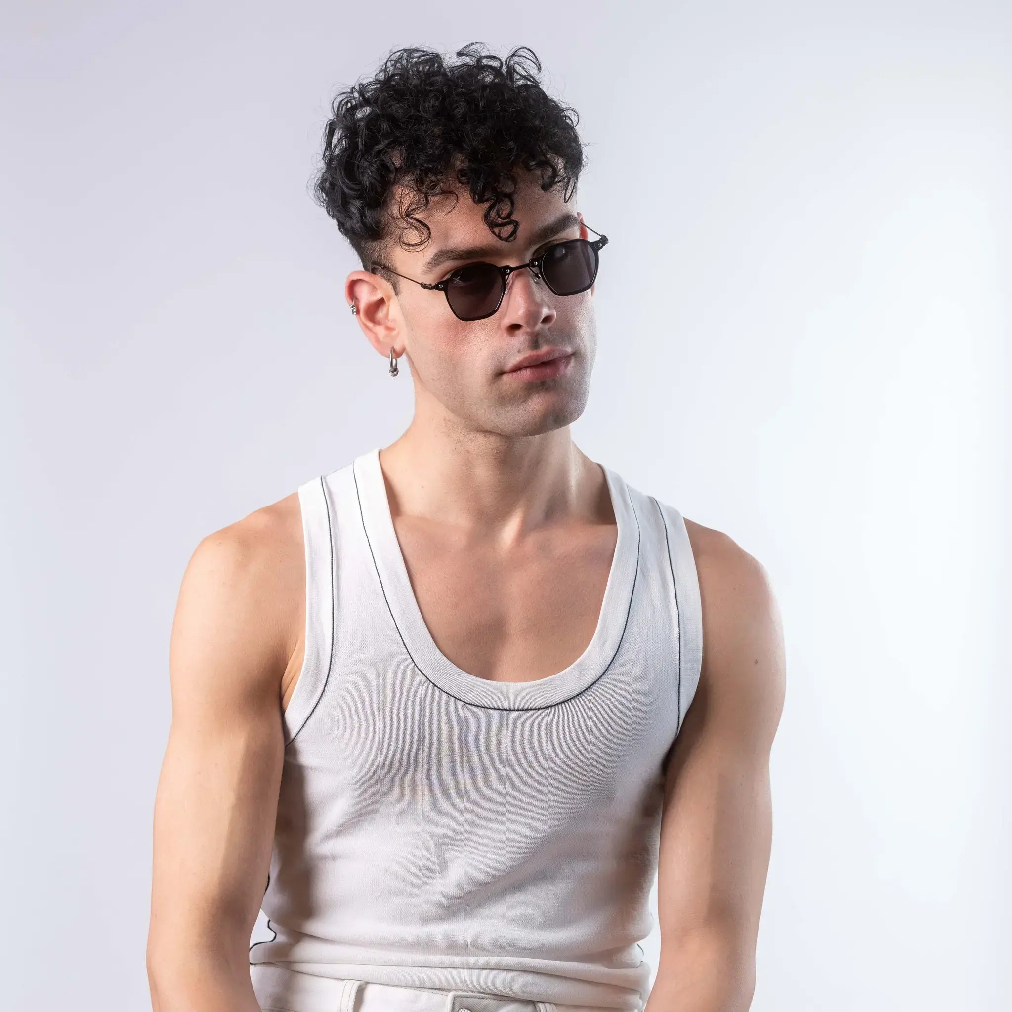 A male model wearing Exposure Sunglasses polarized sunglasses with black frames and black lenses, posing against a white background.