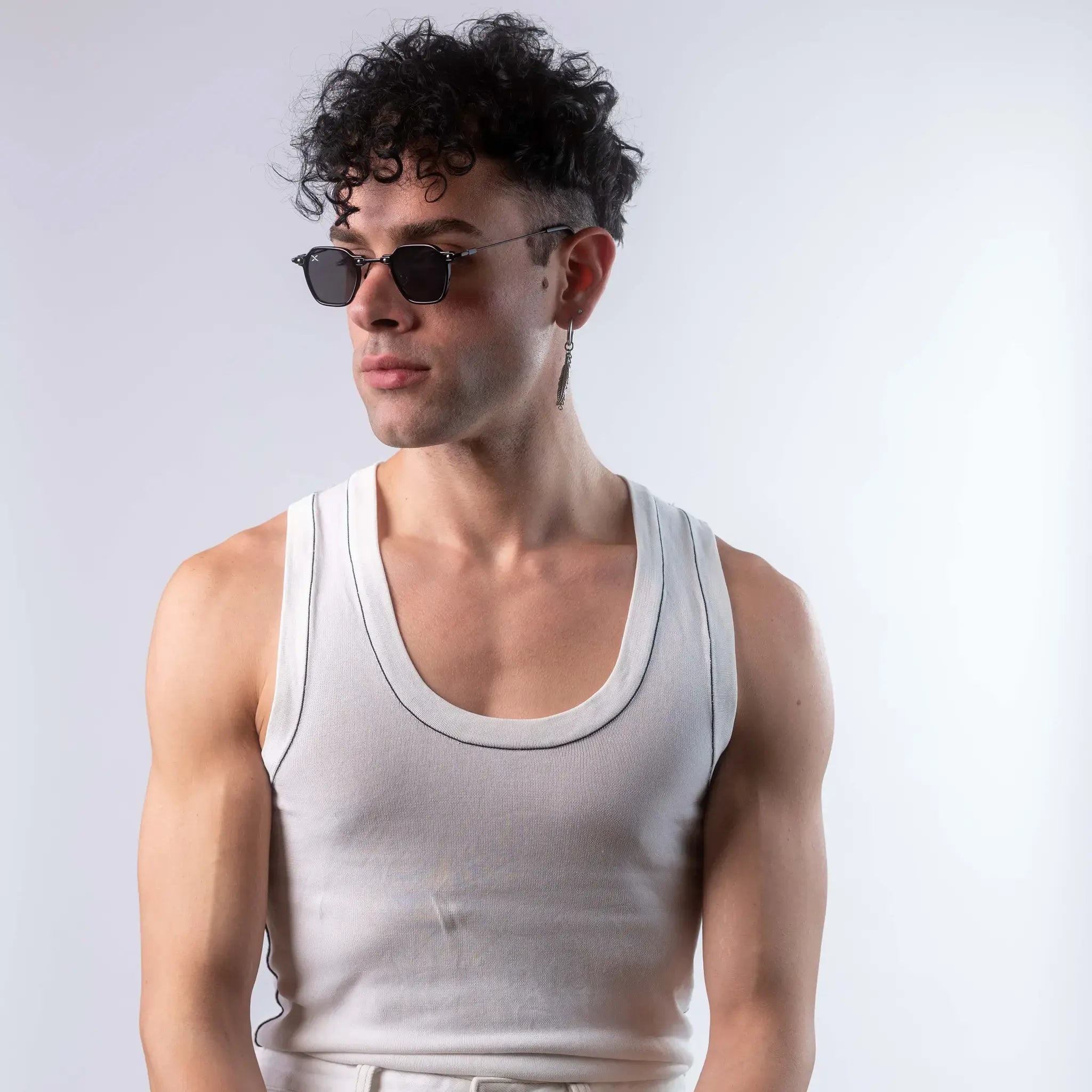 A male model wearing Exposure Sunglasses polarized sunglasses with black frames and black lenses, posing against a white background.