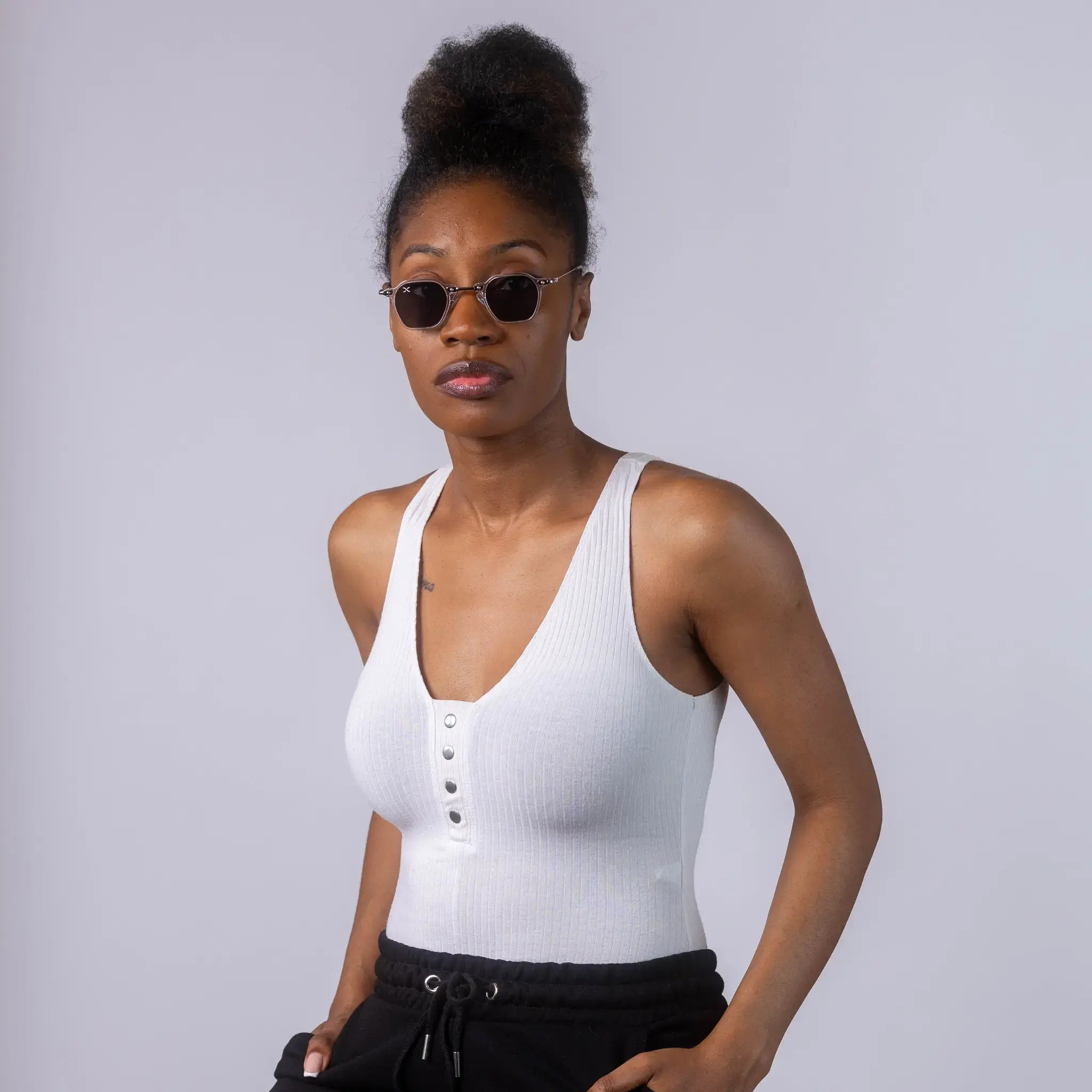 A female model wearing Exposure Sunglasses polarized sunglasses with white frames and black lenses, posing against a white background.