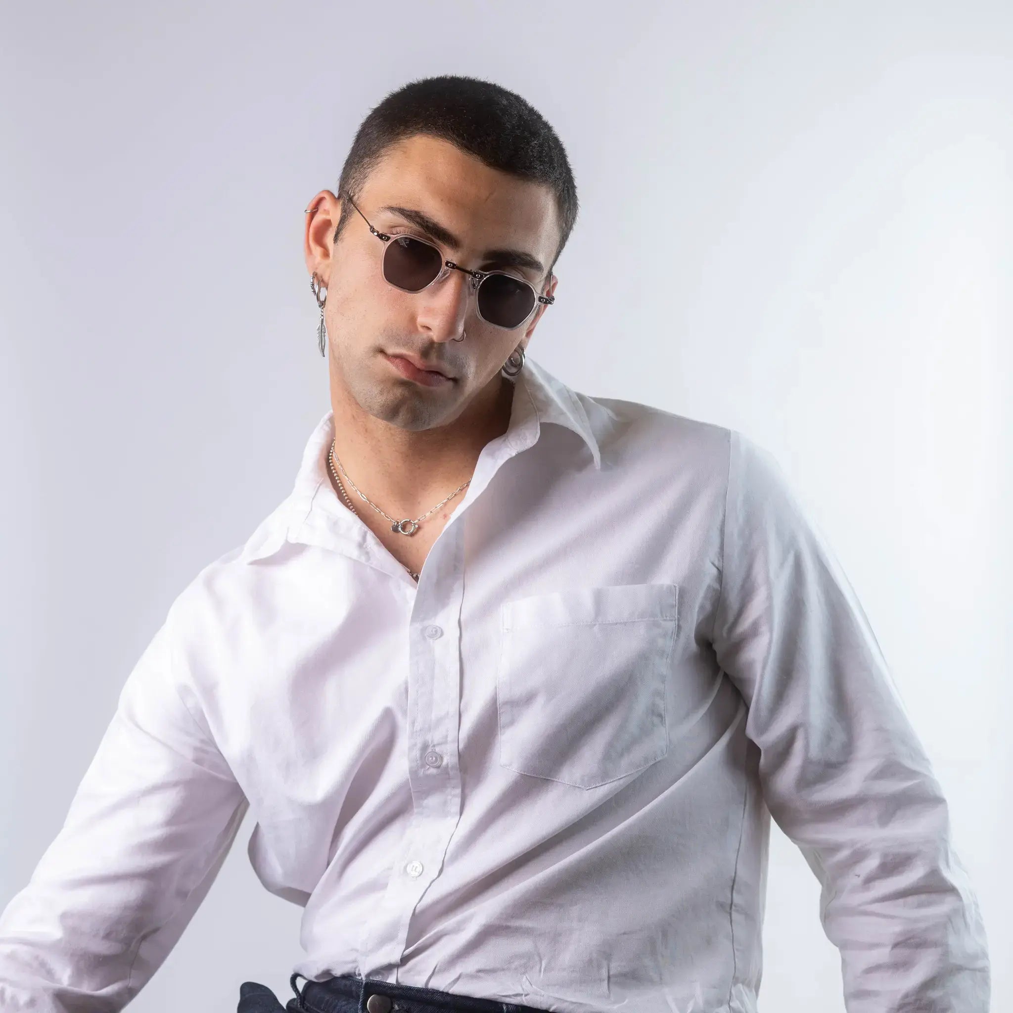 A male model wearing Exposure Sunglasses polarized sunglasses with white frames and black lenses, posing against a white background.