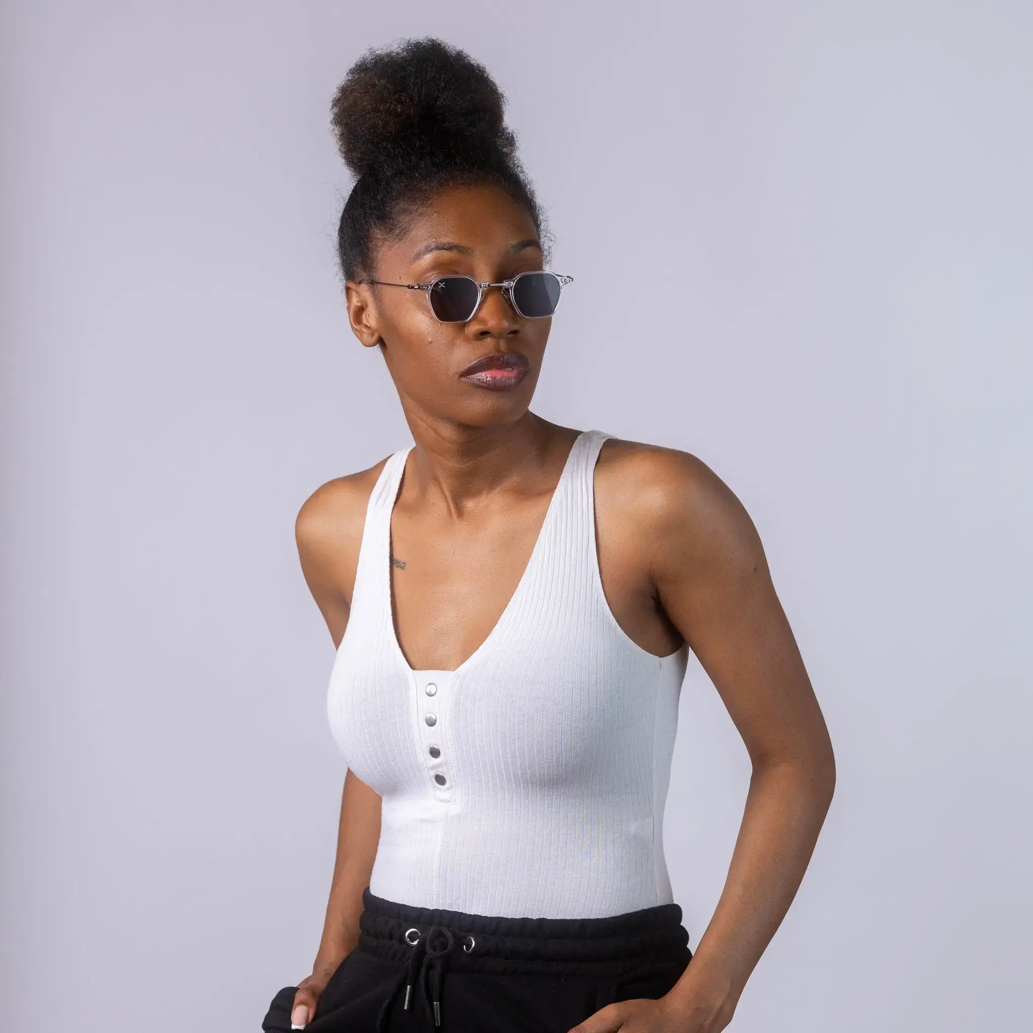 A female model wearing Exposure Sunglasses polarized sunglasses with white frames and black lenses, posing against a white background.