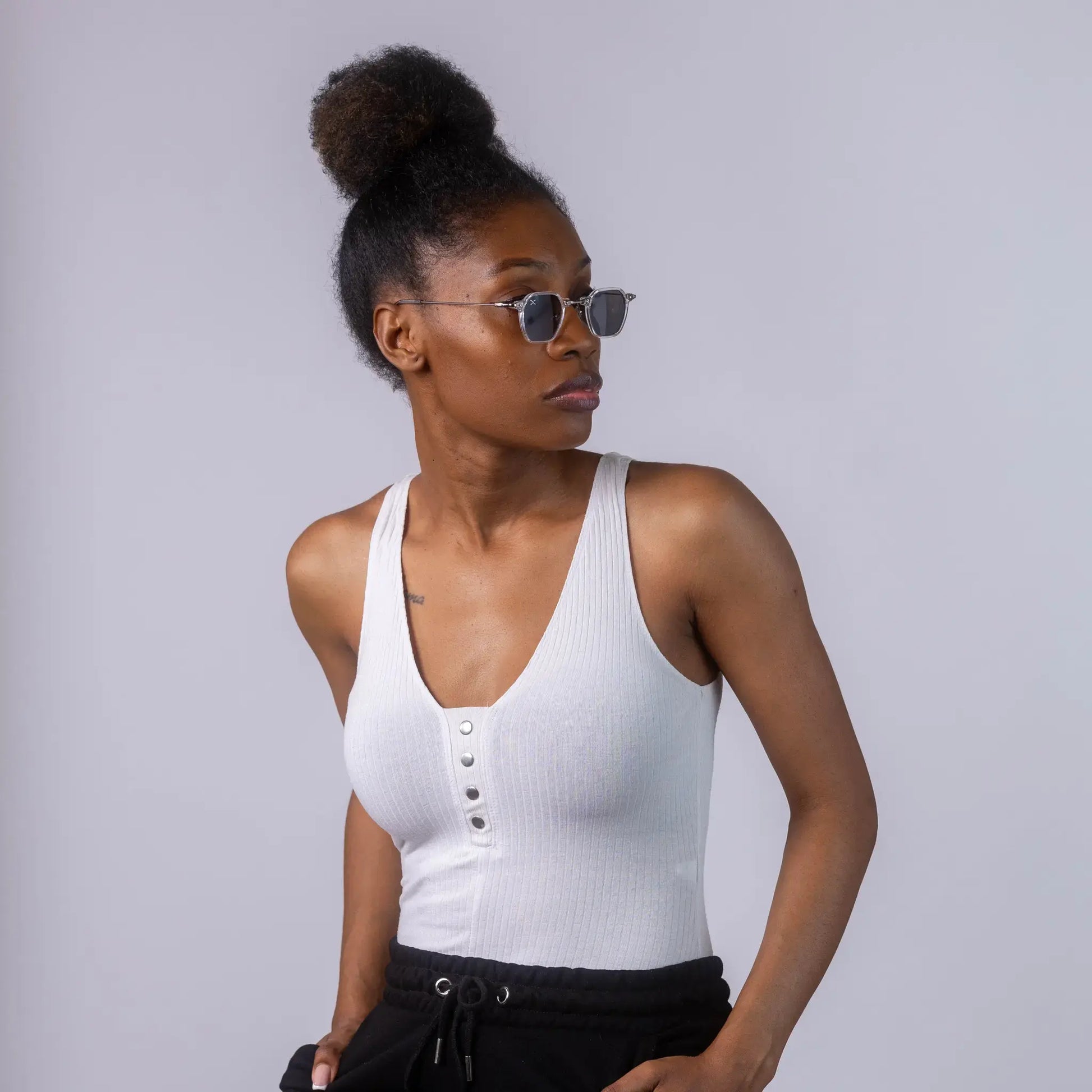 A female model wearing Exposure Sunglasses polarized sunglasses with white frames and black lenses, posing against a white background.