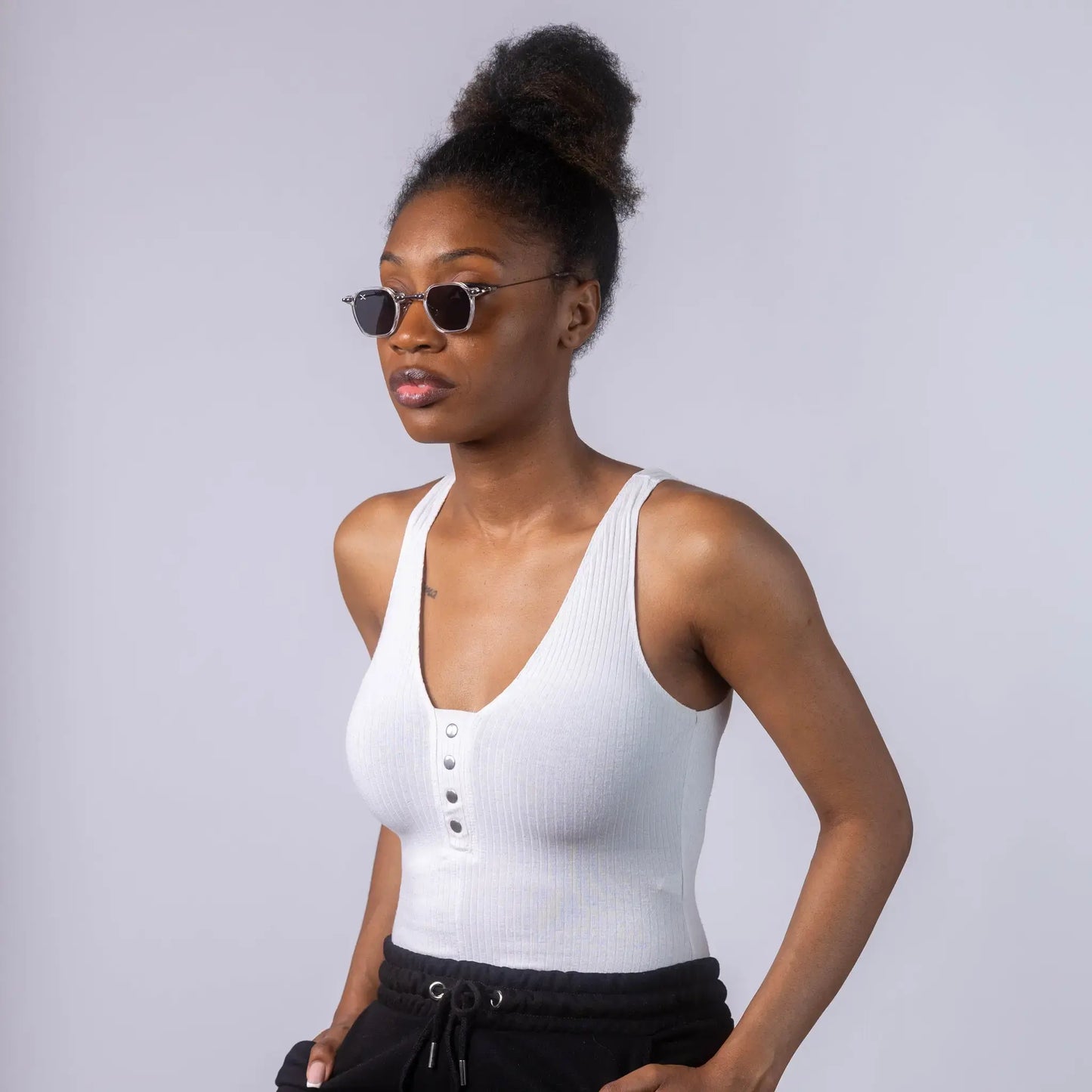 A female model wearing Exposure Sunglasses polarized sunglasses with white frames and black lenses, posing against a white background.