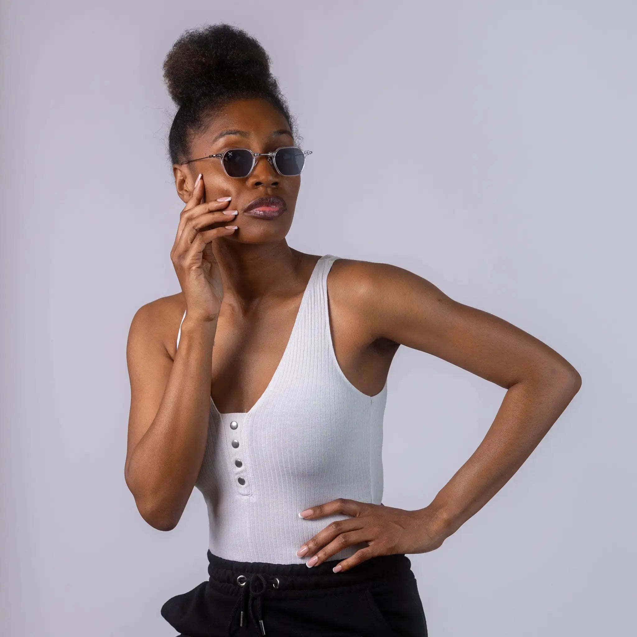 A female model wearing Exposure Sunglasses polarized sunglasses with white frames and black lenses, posing against a white background.