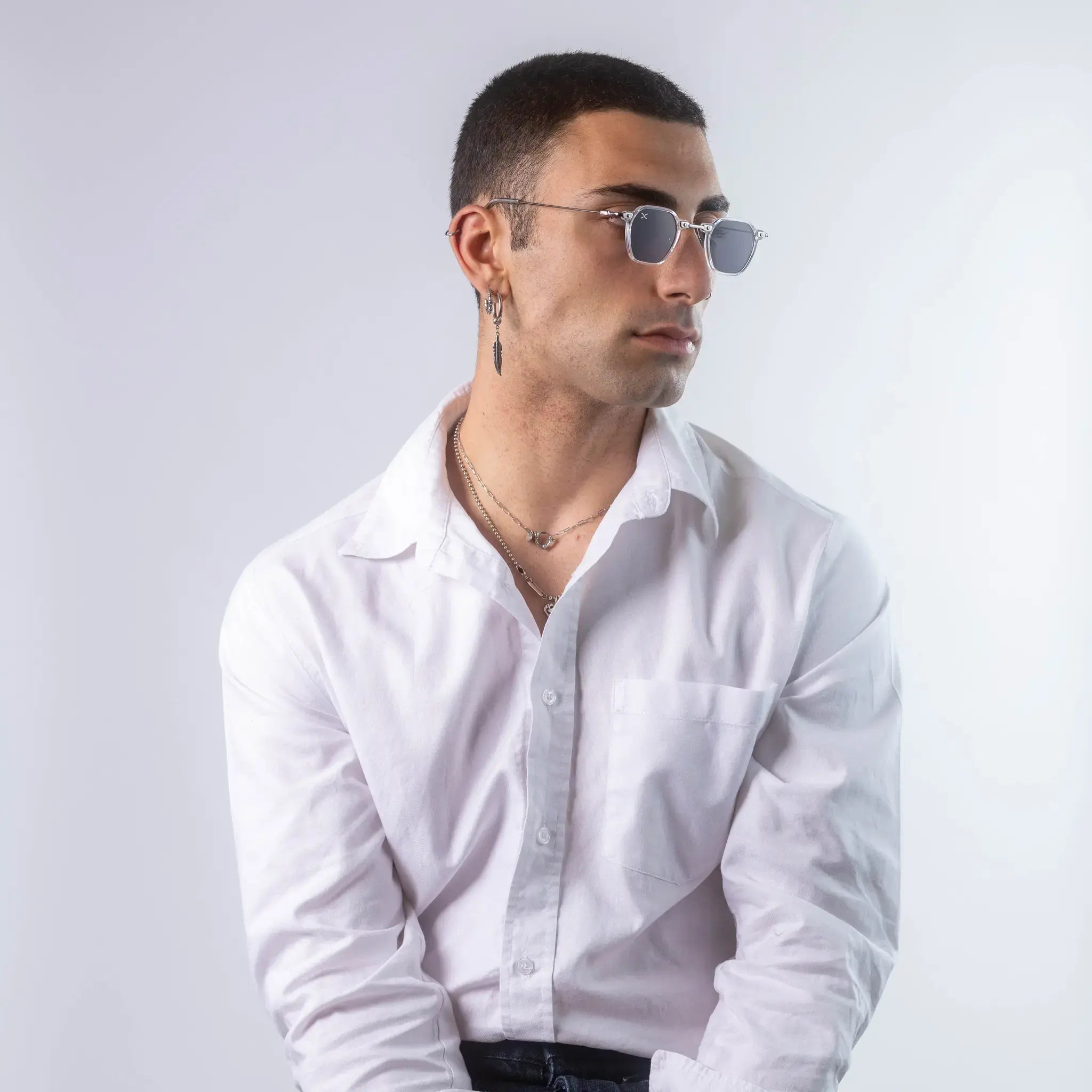 A male model wearing Exposure Sunglasses polarized sunglasses with white frames and black lenses, posing against a white background.