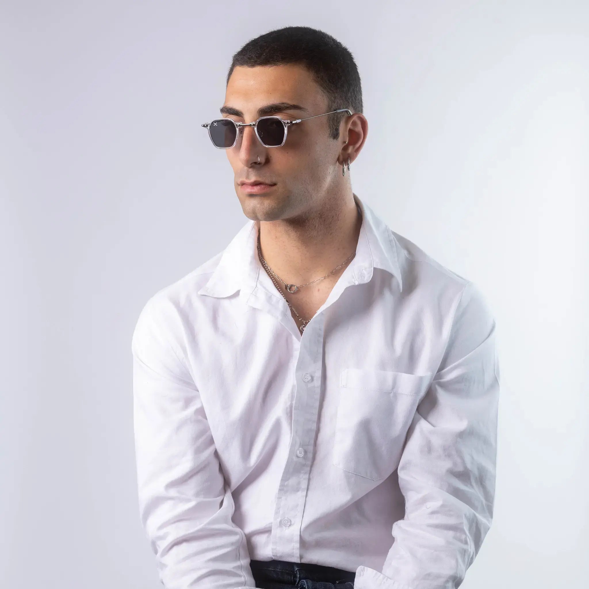 A male model wearing Exposure Sunglasses polarized sunglasses with white frames and black lenses, posing against a white background.