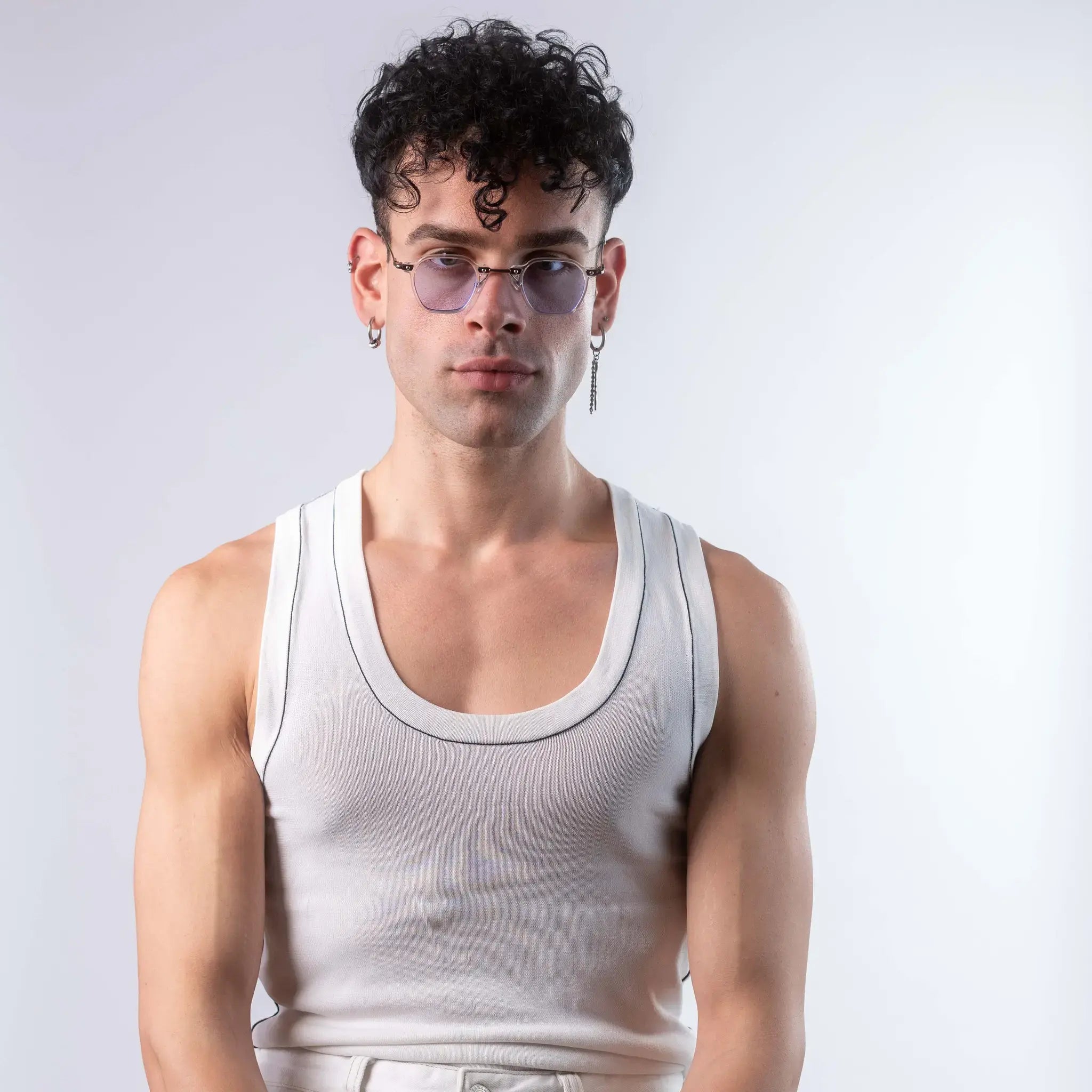 A male model wearing Exposure Sunglasses polarized sunglasses with white frames and blue lenses, posing against a white background.