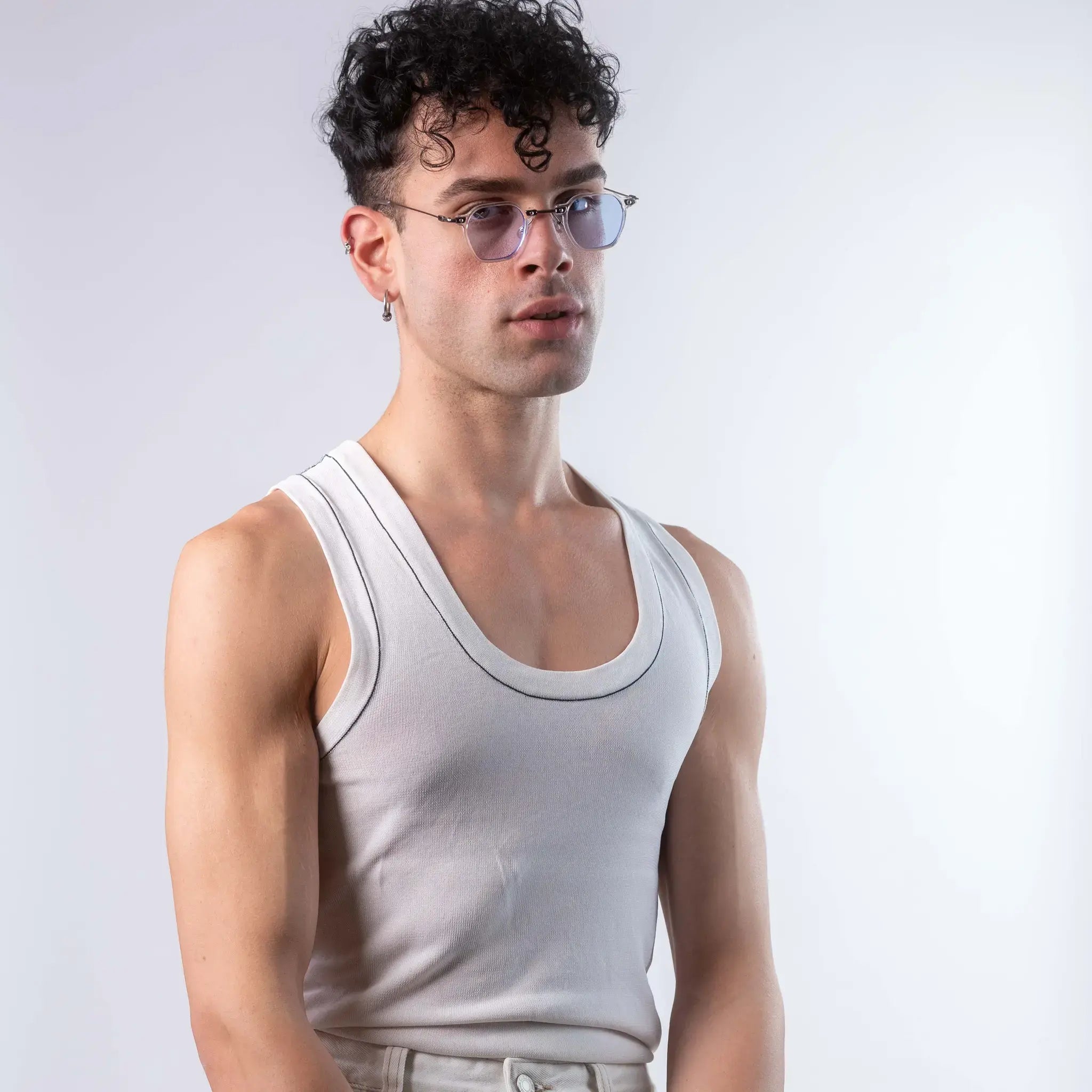 A male model wearing Exposure Sunglasses polarized sunglasses with white frames and blue lenses, posing against a white background.