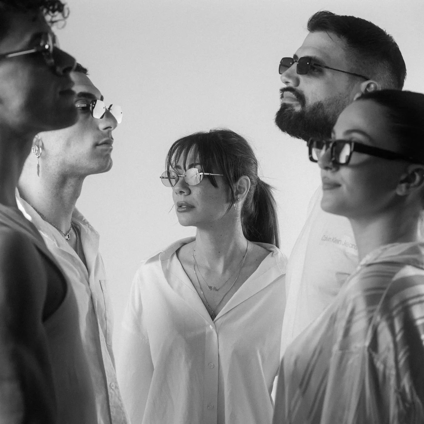 Five models wearing Exposure Sunglasses polarized sunglasses with silver frames and tinted lenses.