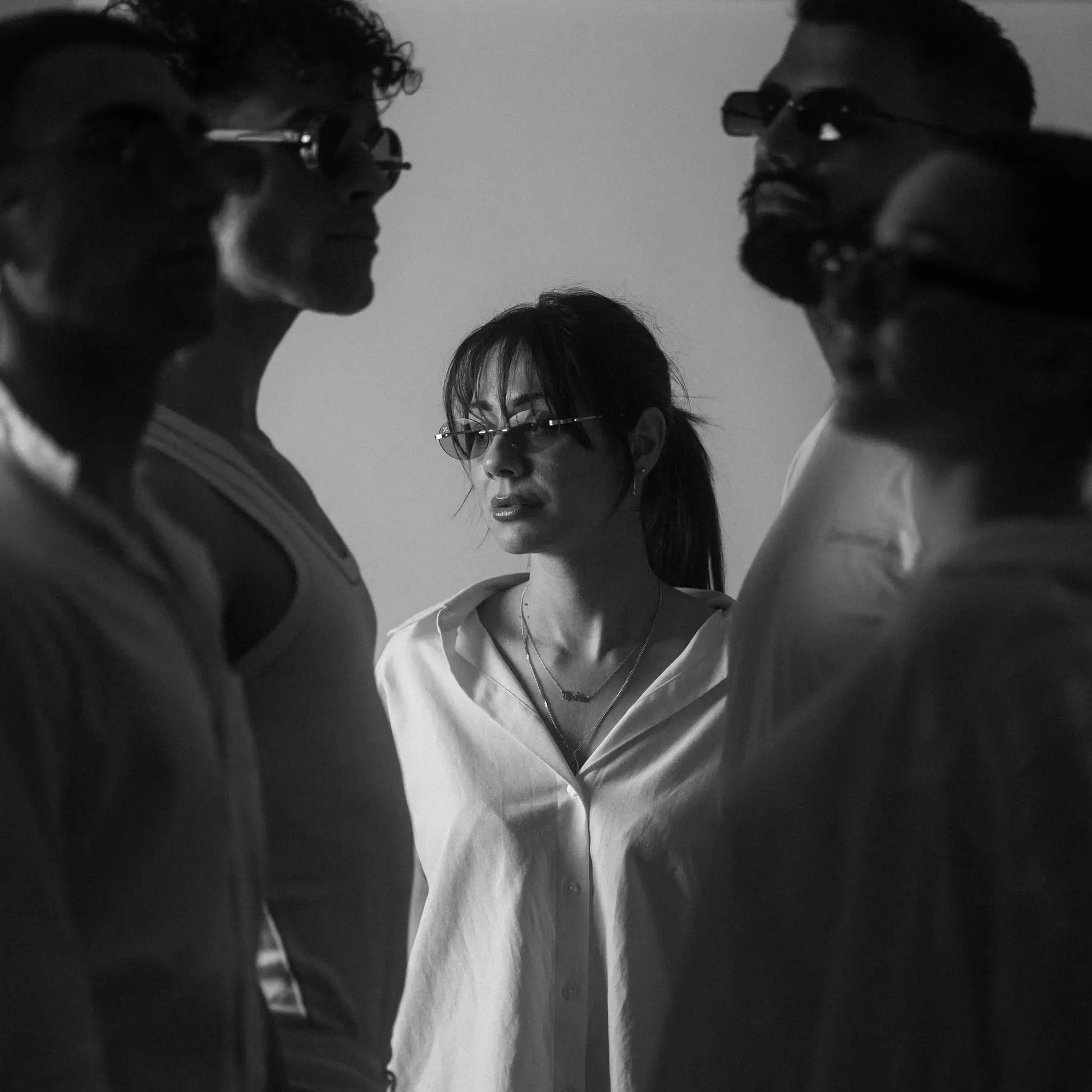 Five models wearing Exposure Sunglasses polarized sunglasses with silver frames and tinted lenses.