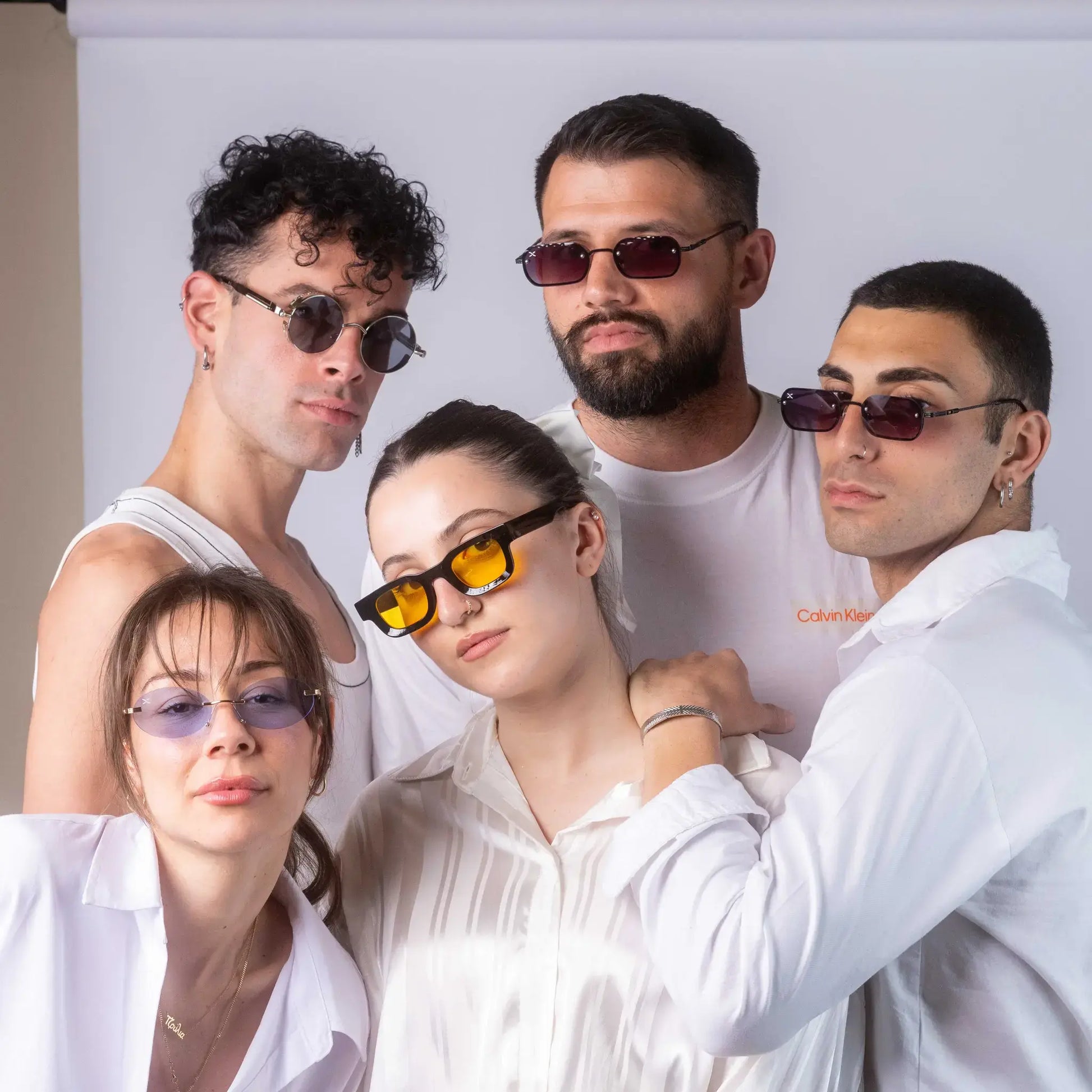 Five models wearing Exposure Sunglasses polarized sunglasses with silver frames and tinted lenses.