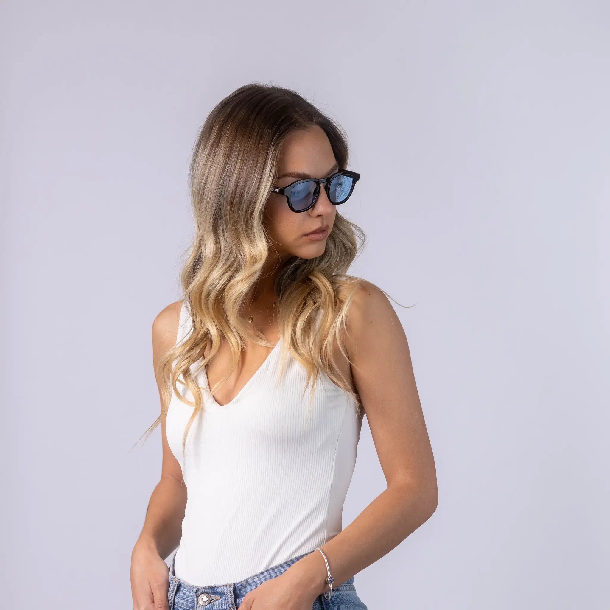 Γυαλιά ηλίου Montreal της Exposure Sunglasses με προστασία UV400 με μαύρο σκελετό και μπλε φακό. Φορεμένα από μοντέλο.