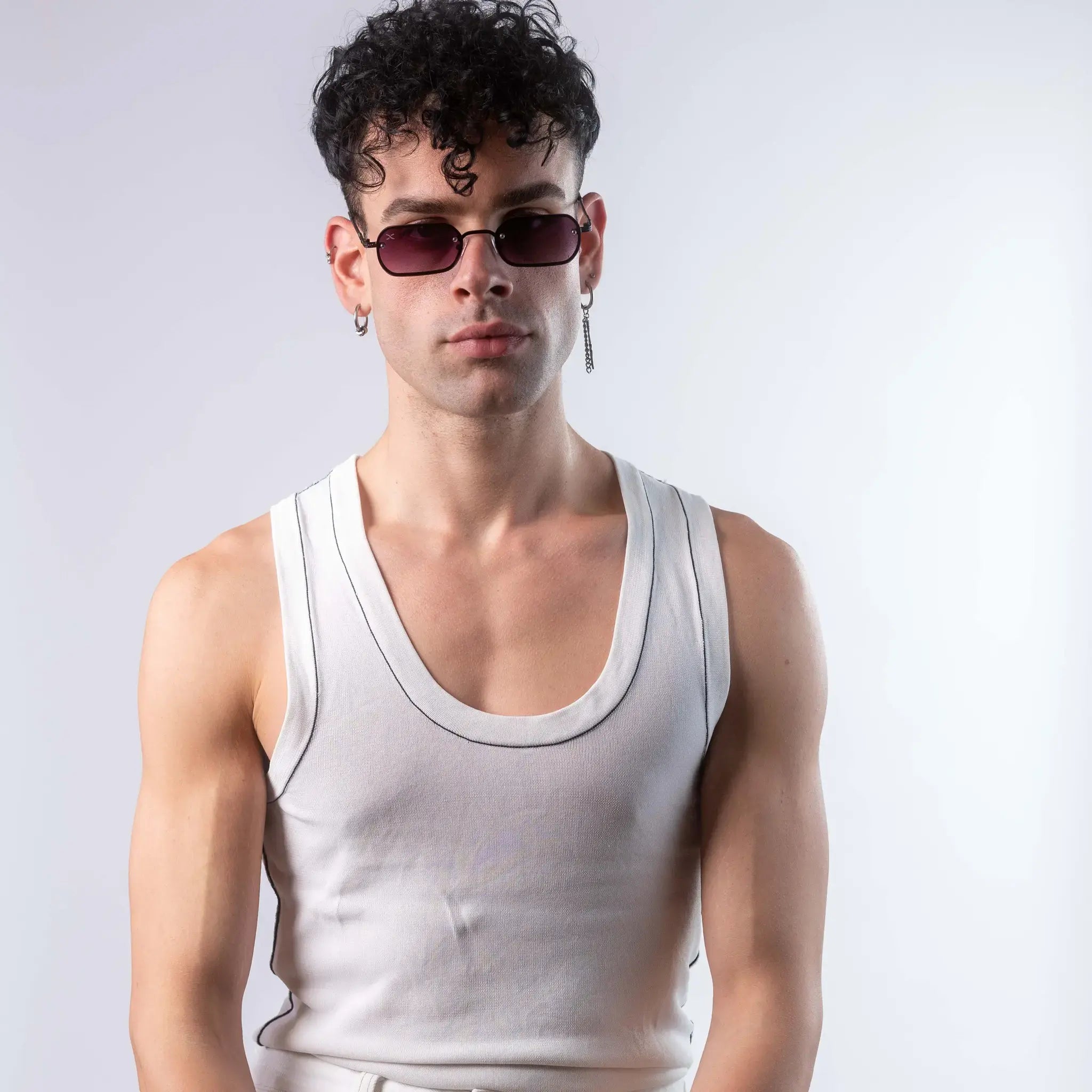 A male model wearing Exposure Sunglasses polarized sunglasses with black frames and purple lenses, posing against a white background.