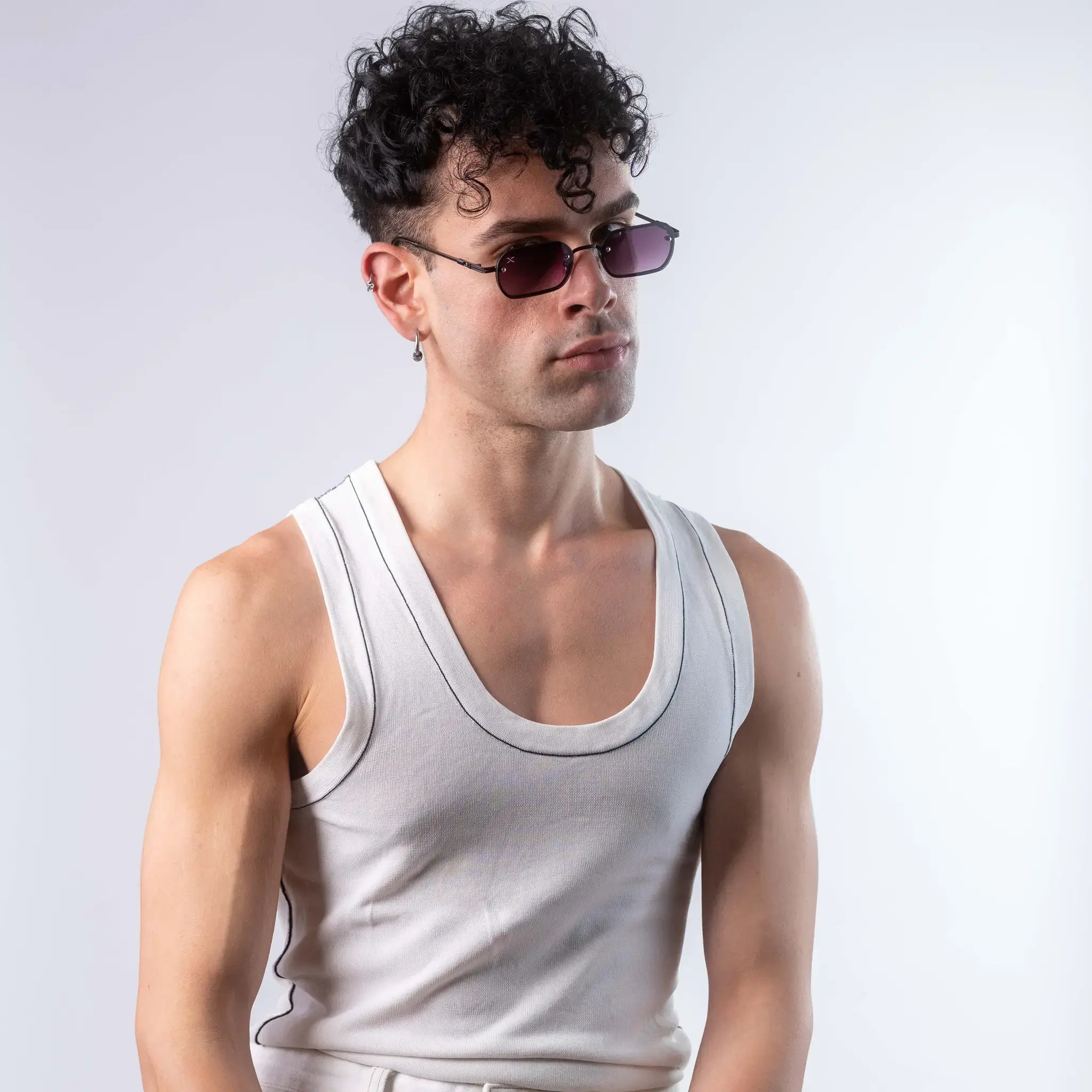 A male model wearing Exposure Sunglasses polarized sunglasses with black frames and purple lenses, posing against a white background.