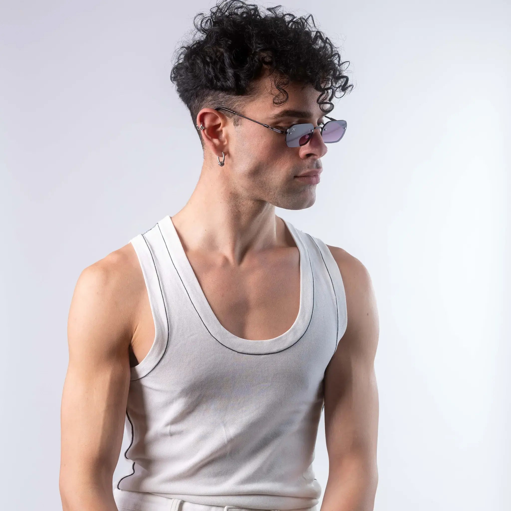 A male model wearing Exposure Sunglasses polarized sunglasses with black frames and purple lenses, posing against a white background.