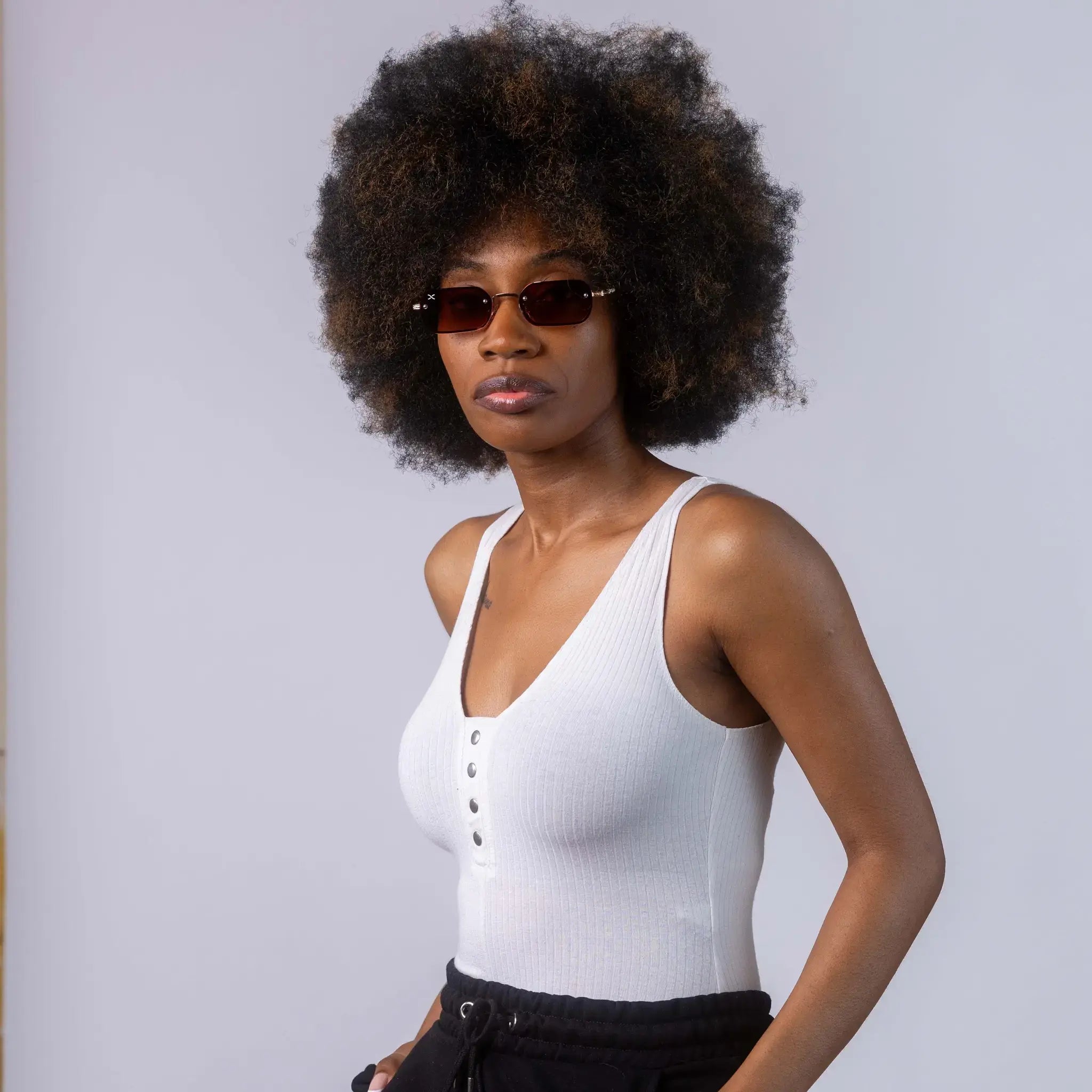 A female model wearing Exposure Sunglasses polarized sunglasses with gold frames and brown lenses, posing against a white background.