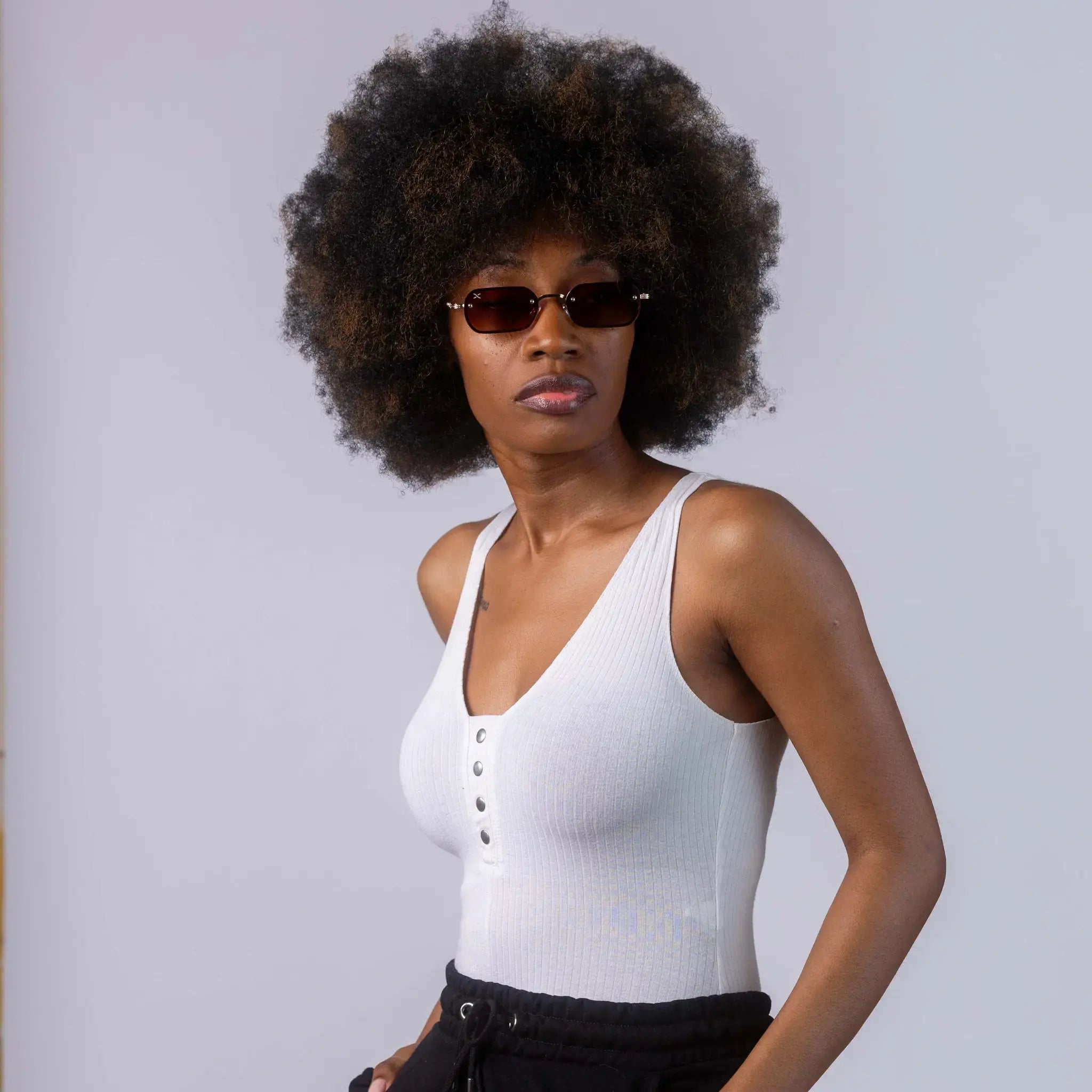 A female model wearing Exposure Sunglasses polarized sunglasses with gold frames and brown lenses, posing against a white background.