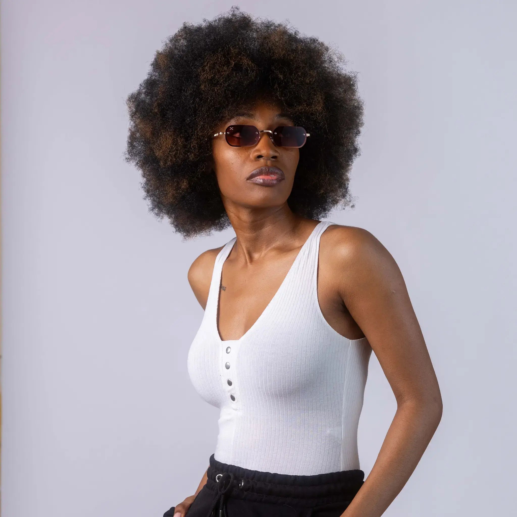 A female model wearing Exposure Sunglasses polarized sunglasses with gold frames and brown lenses, posing against a white background.