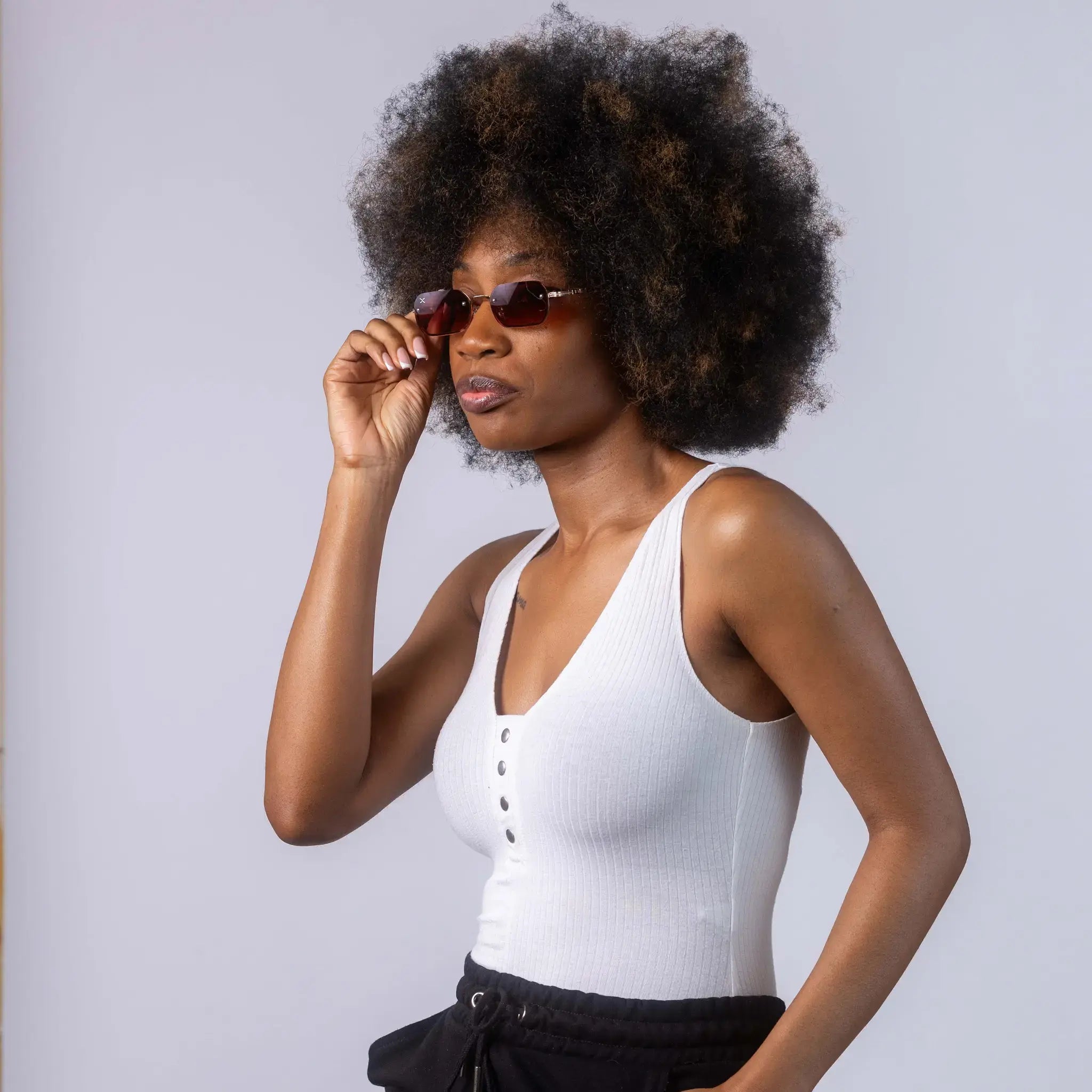 A female model wearing Exposure Sunglasses polarized sunglasses with gold frames and brown lenses, posing against a white background.