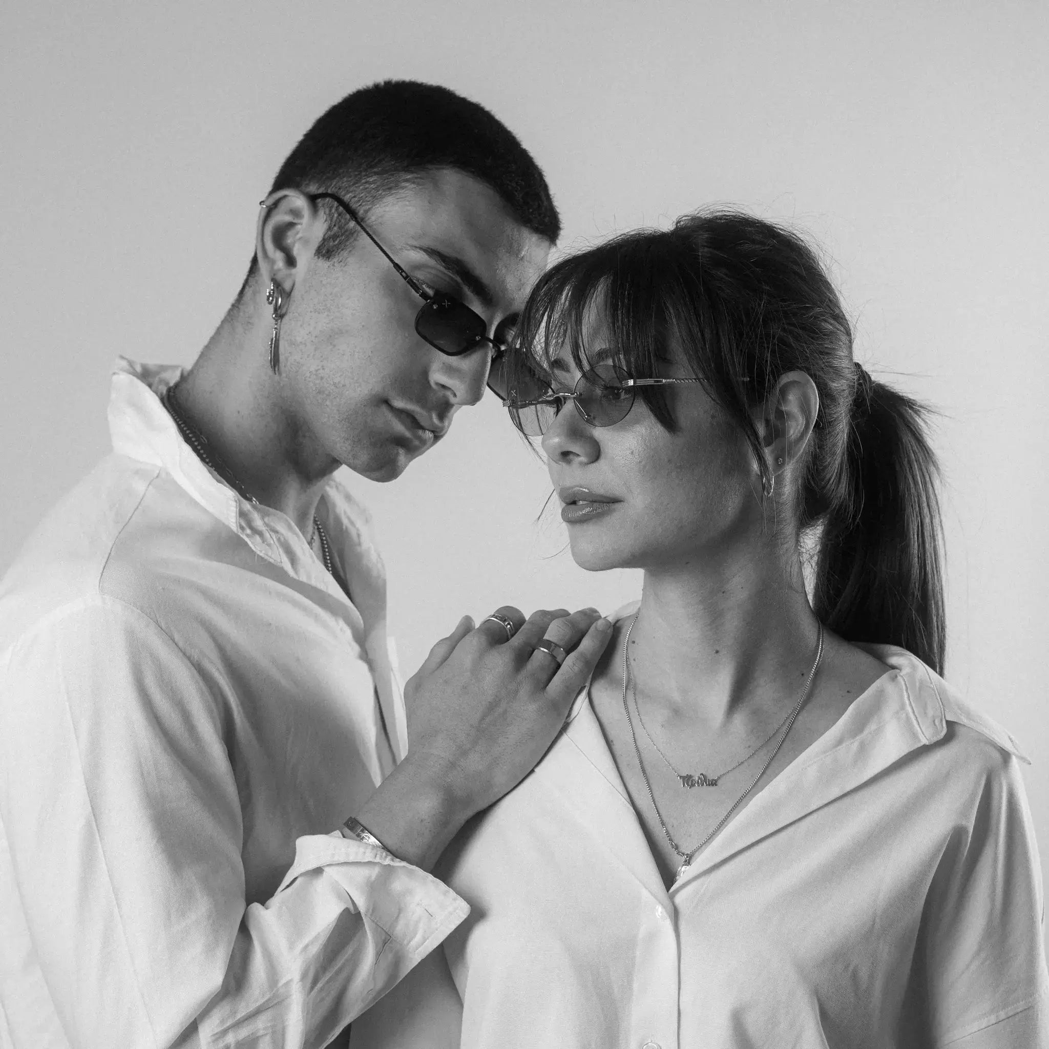 Two models wearing Exposure Sunglasses polarized sunglasses with black frames and orange lenses, posing against a white background.