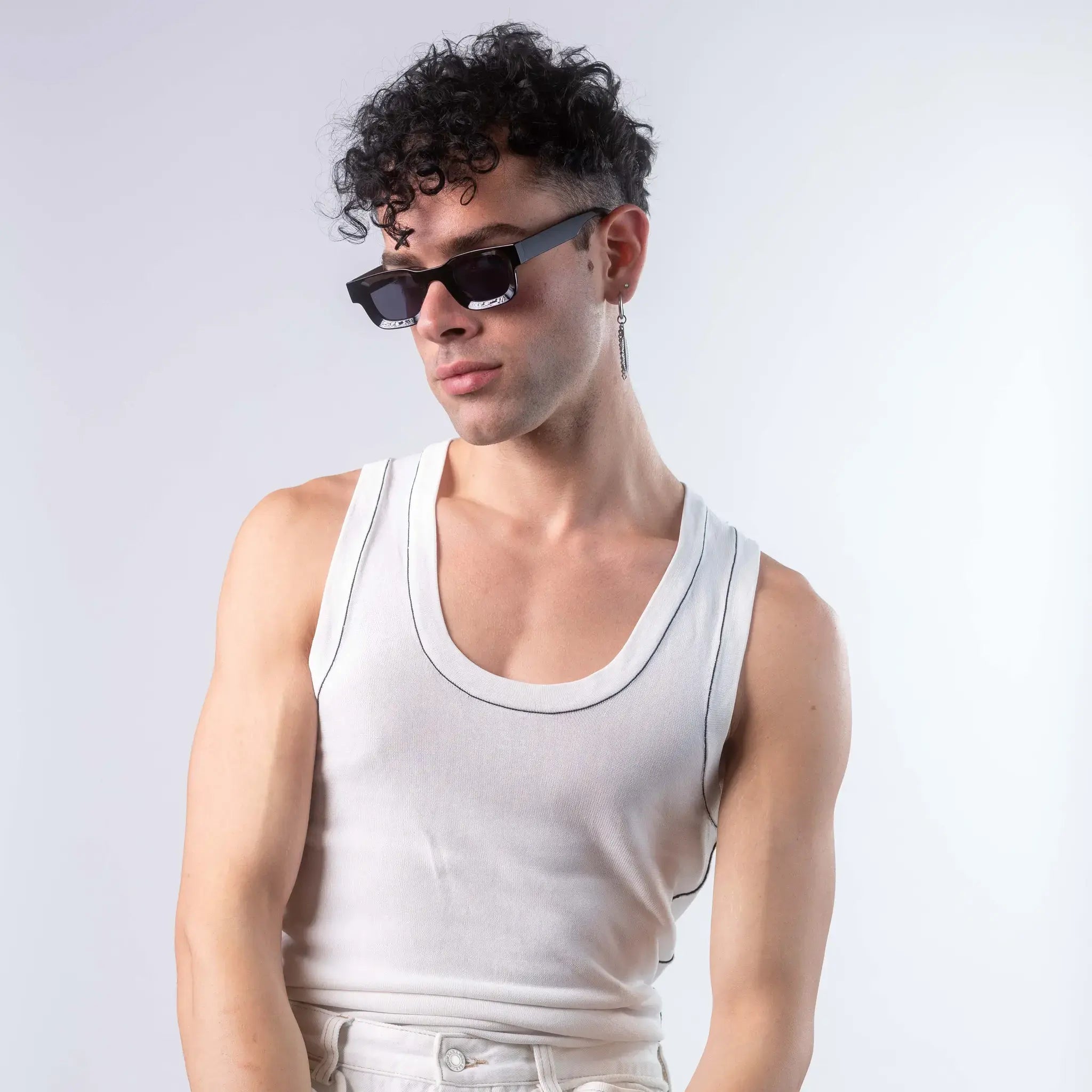 A male model wearing Exposure Sunglasses polarized sunglasses with black frames and black lenses, posing against a white background.