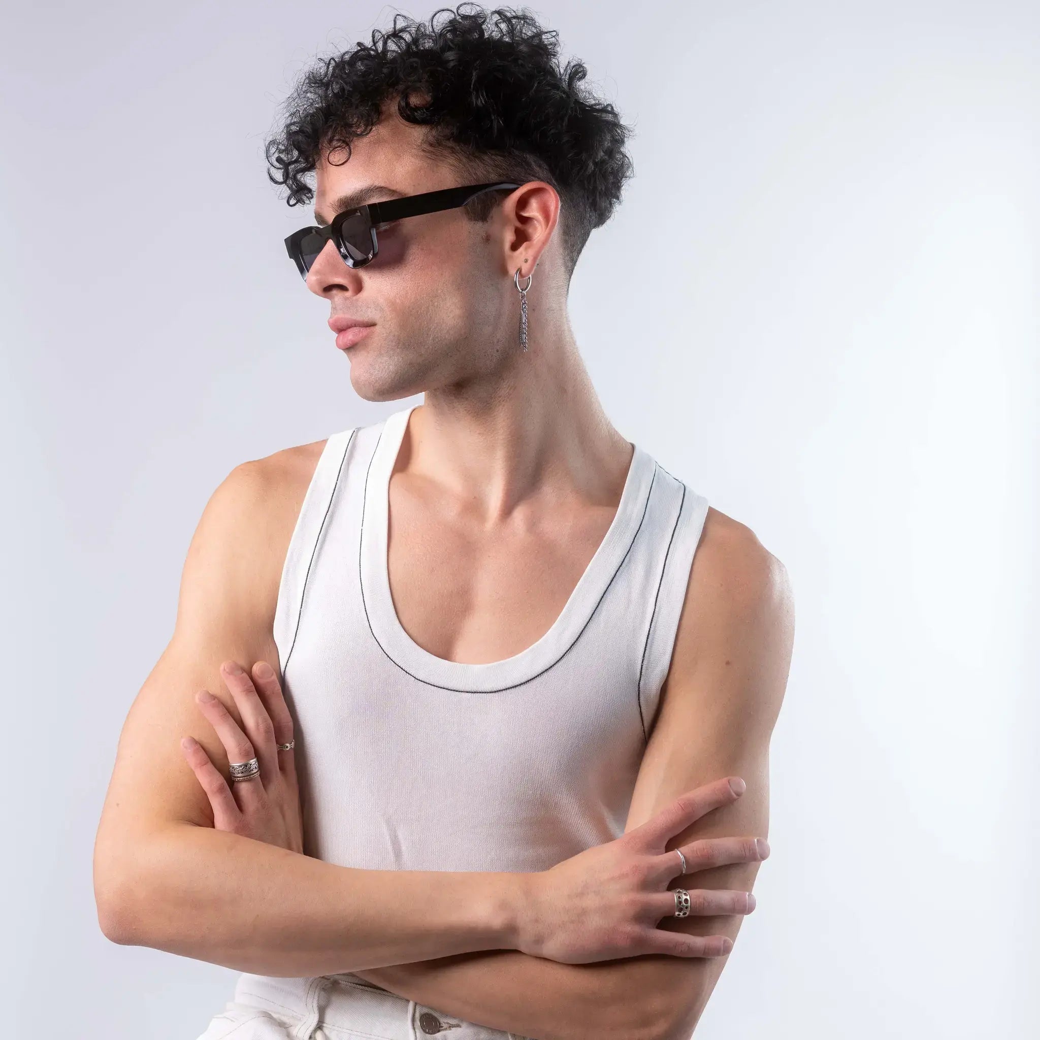 A male model wearing Exposure Sunglasses polarized sunglasses with black frames and black lenses, posing against a white background.