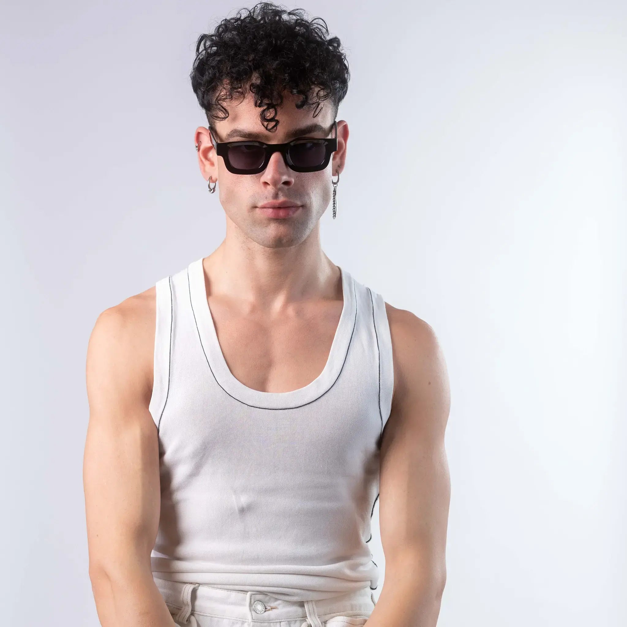 A male model wearing Exposure Sunglasses polarized sunglasses with black frames and black lenses, posing against a white background.