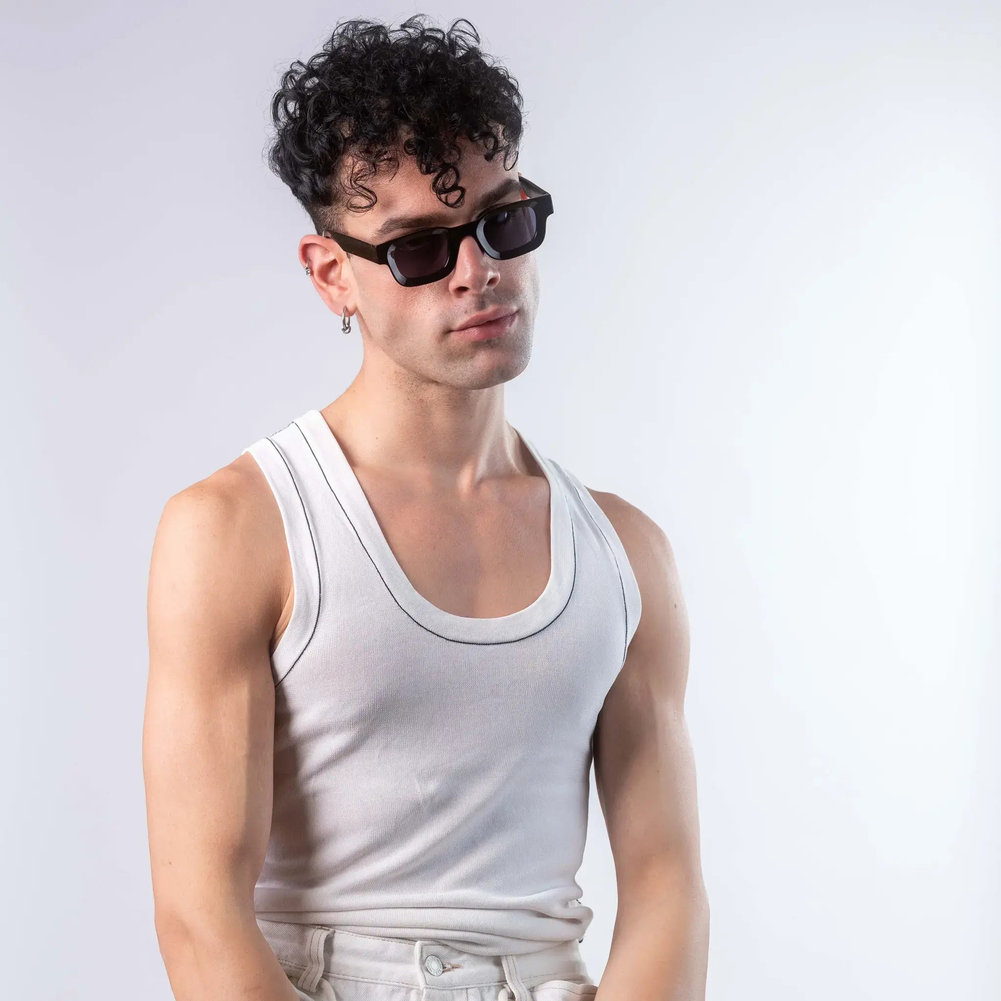 A male model wearing Exposure Sunglasses polarized sunglasses with black frames and black lenses, posing against a white background.