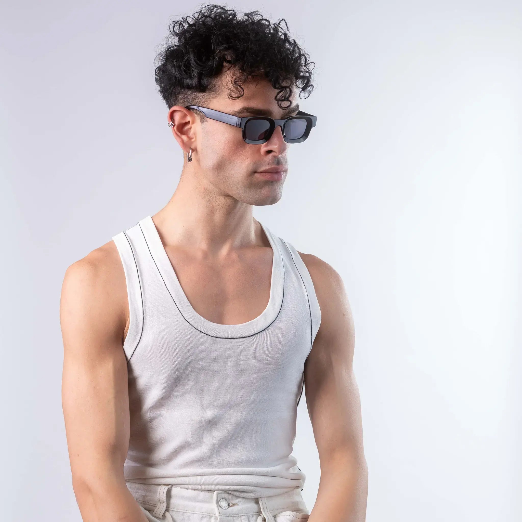 A male model wearing Exposure Sunglasses polarized sunglasses with black frames and black lenses, posing against a white background.