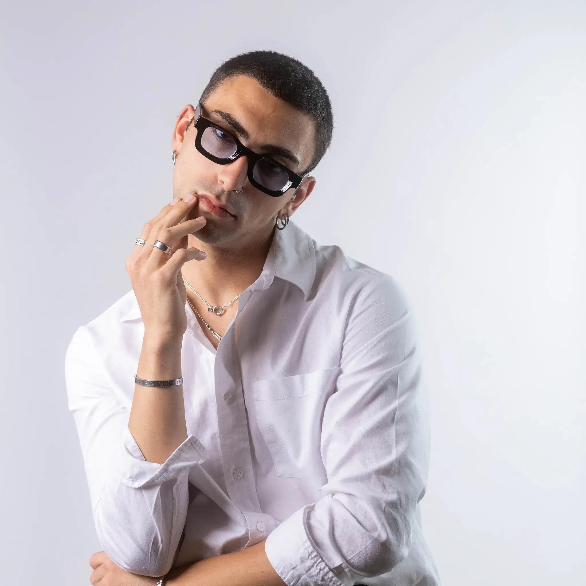 A male model wearing Exposure Sunglasses polarized sunglasses with black frames and blue lenses, posing against a white background.