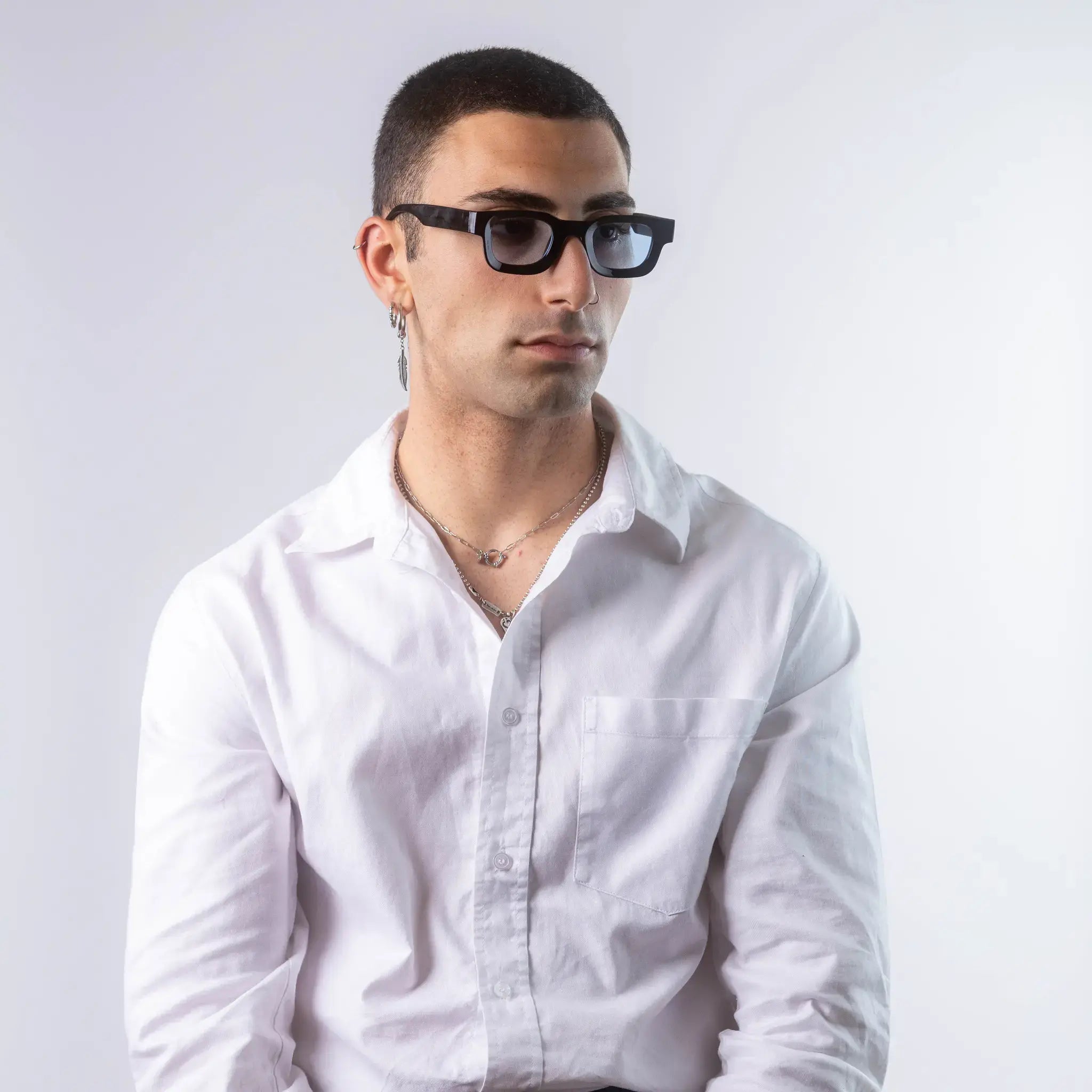 A male model wearing Exposure Sunglasses polarized sunglasses with black frames and blue lenses, posing against a white background.