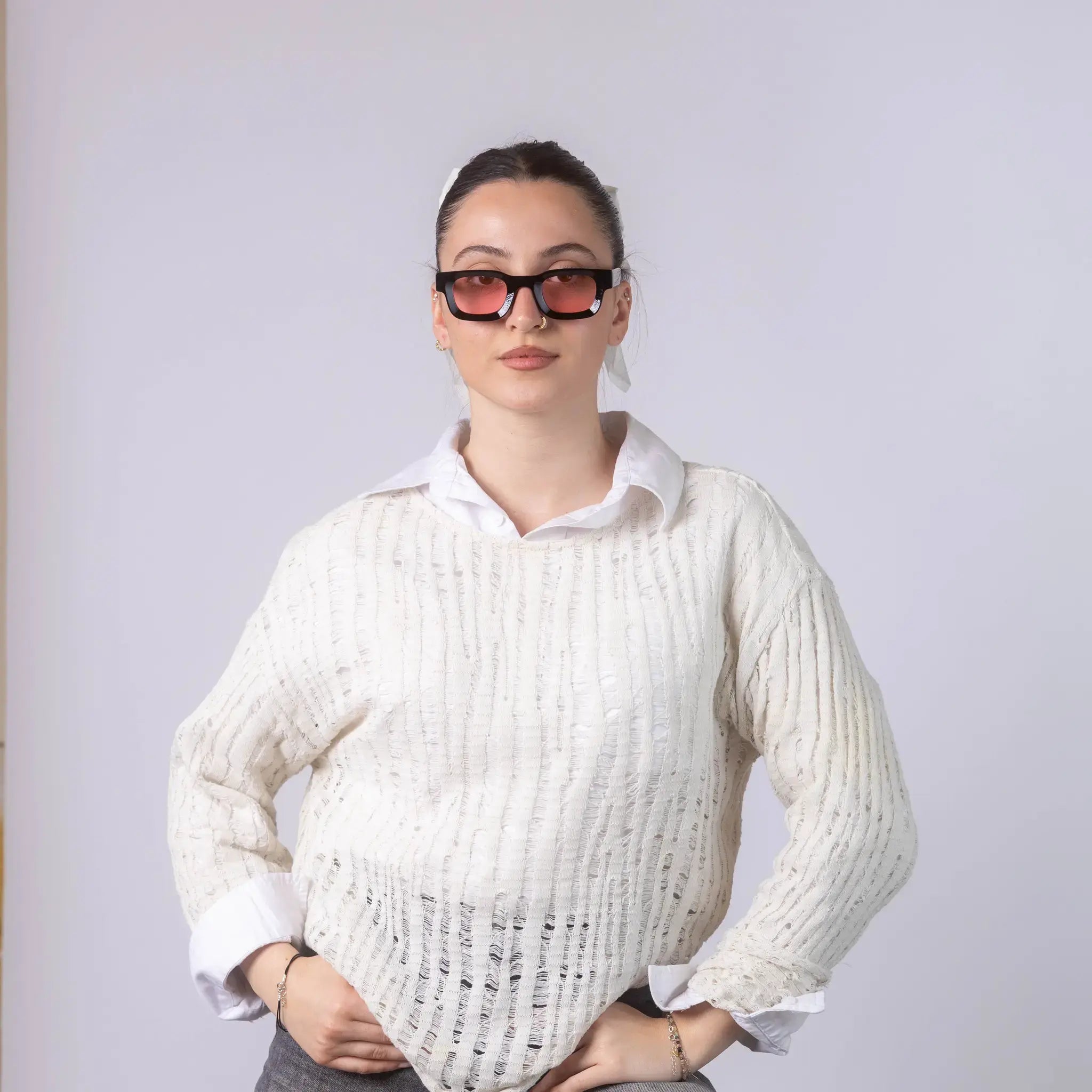 A female model wearing Exposure Sunglasses polarized sunglasses with black frames and pink lenses, posing against a white background.