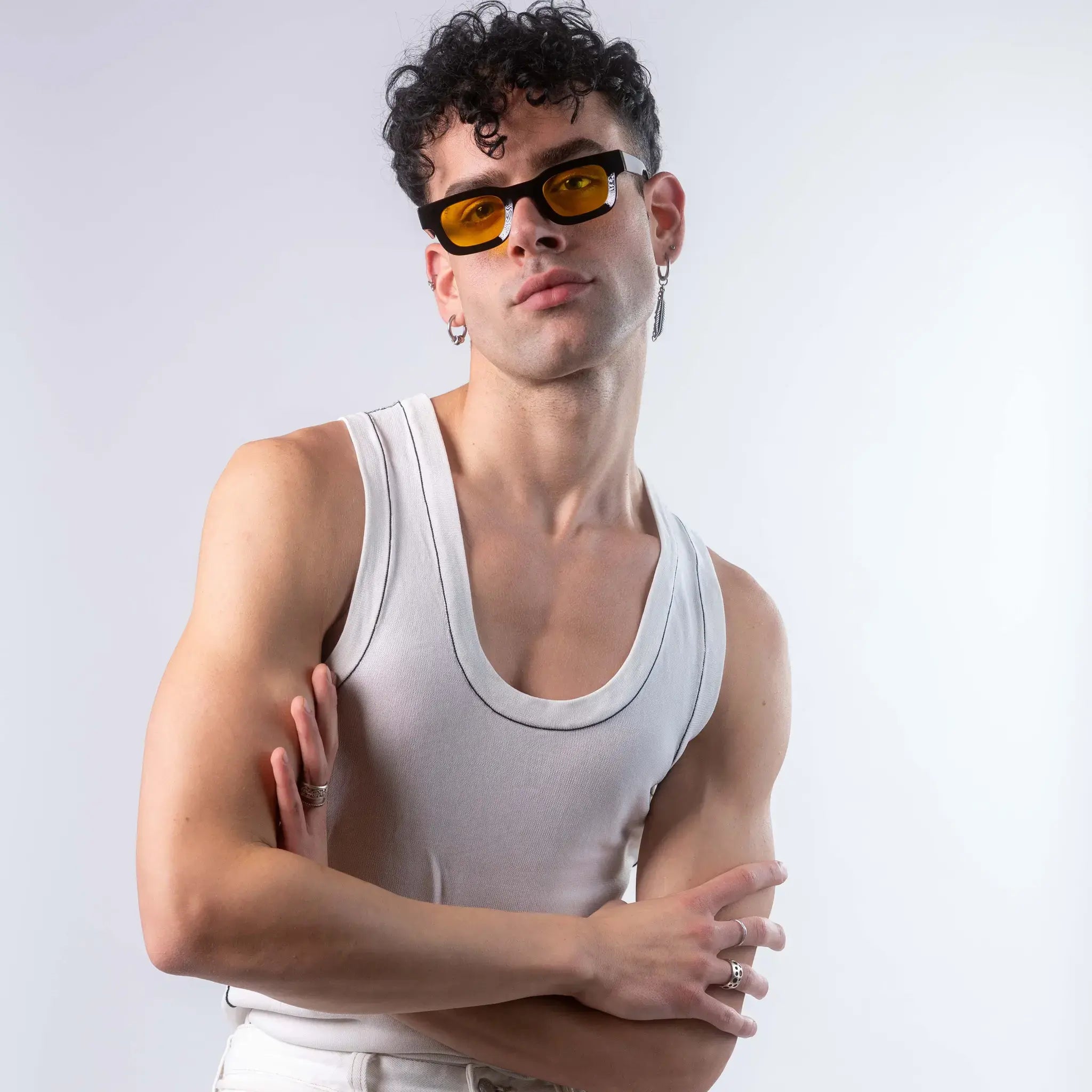 A male model wearing Exposure Sunglasses polarized sunglasses with black frames and yellow lenses, posing against a white background.