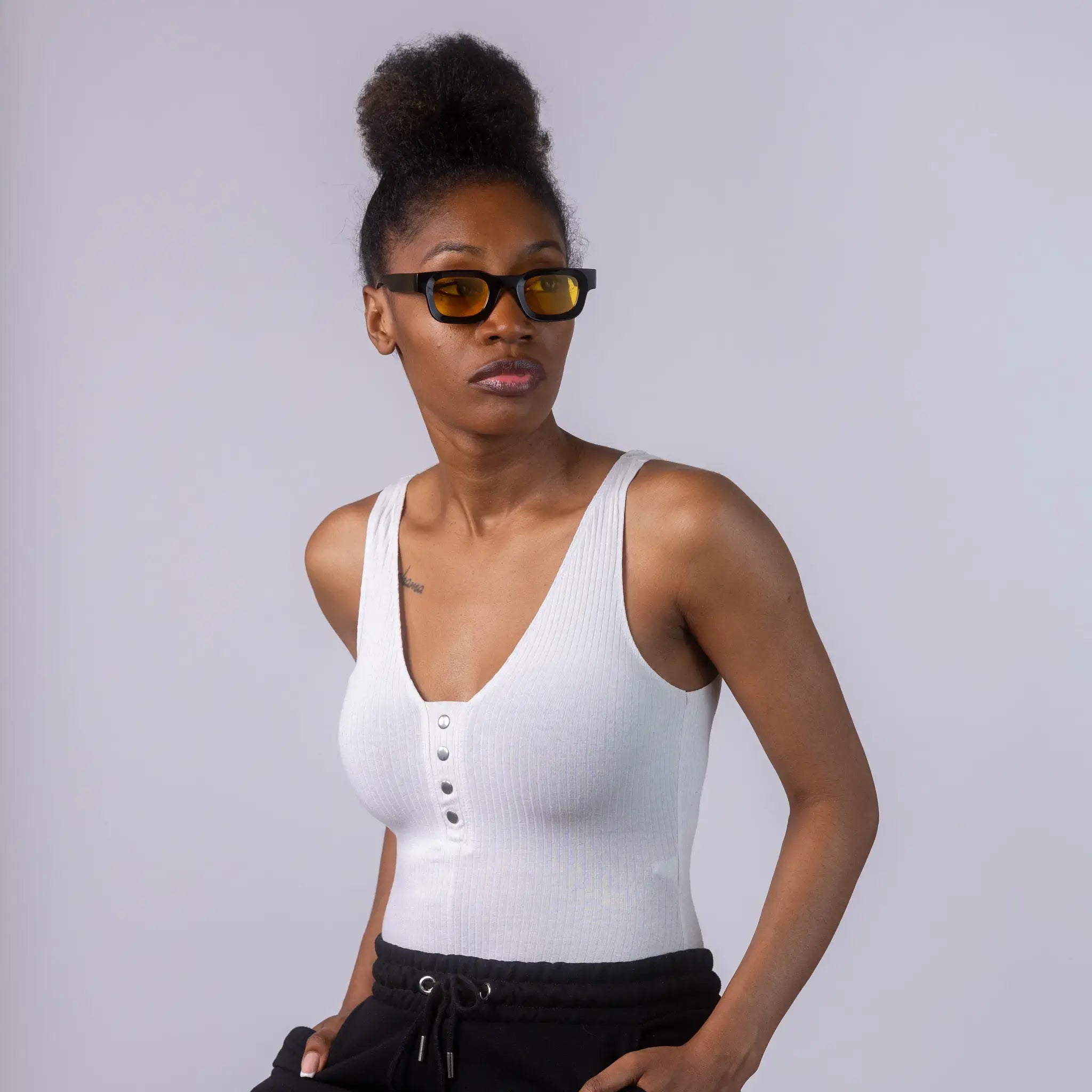 A female model wearing Exposure Sunglasses polarized sunglasses with black frames and yellow lenses, posing against a white background.