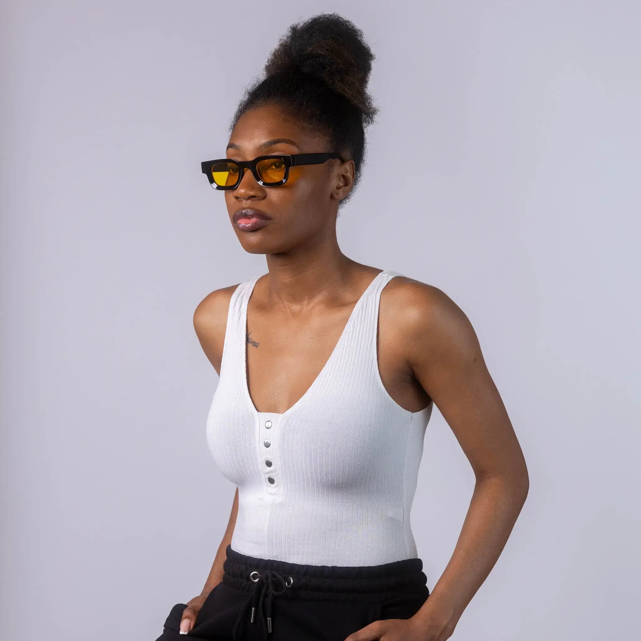 A female model wearing Exposure Sunglasses polarized sunglasses with black frames and yellow lenses, posing against a white background.