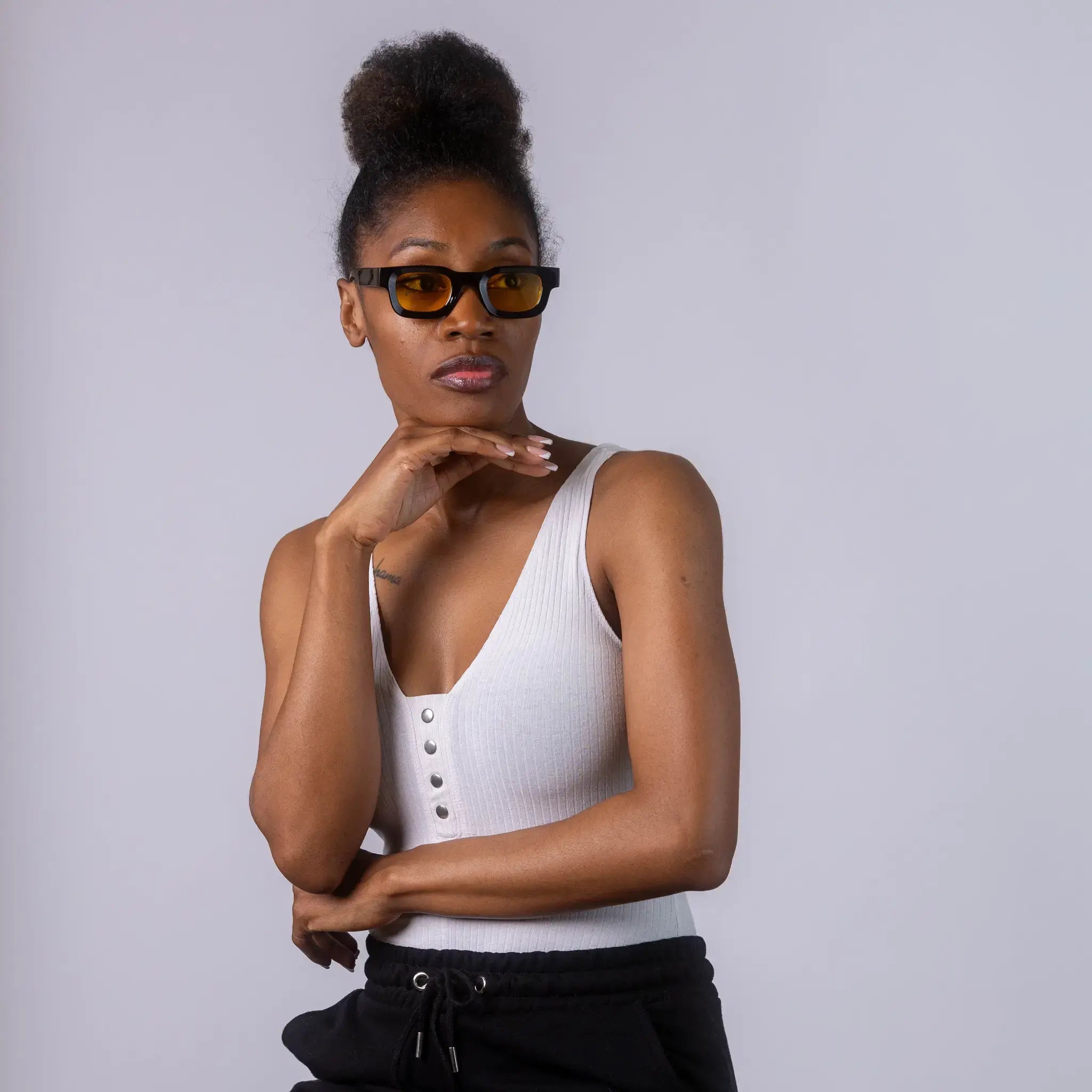 A female model wearing Exposure Sunglasses polarized sunglasses with black frames and yellow lenses, posing against a white background.