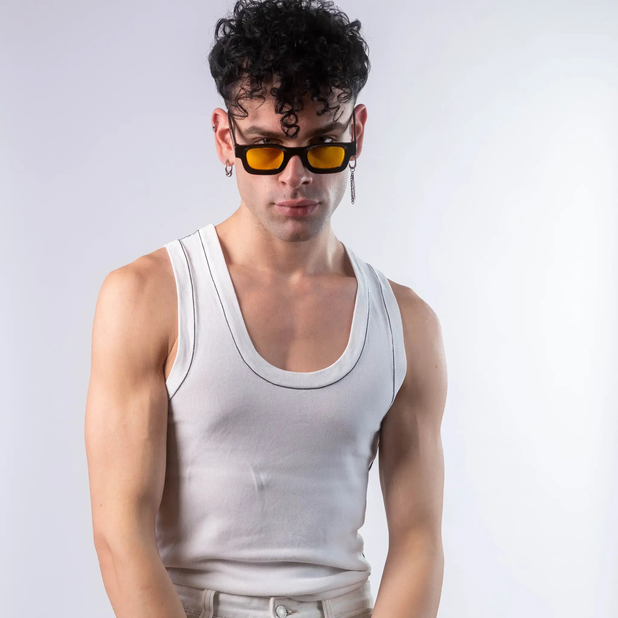 A male model wearing Exposure Sunglasses polarized sunglasses with black frames and yellow lenses, posing against a white background.