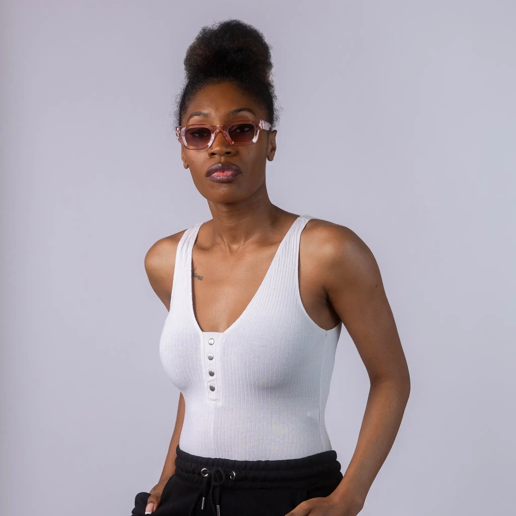 A female model wearing Exposure Sunglasses polarized sunglasses with pink frames and blue lenses, posing against a white background.