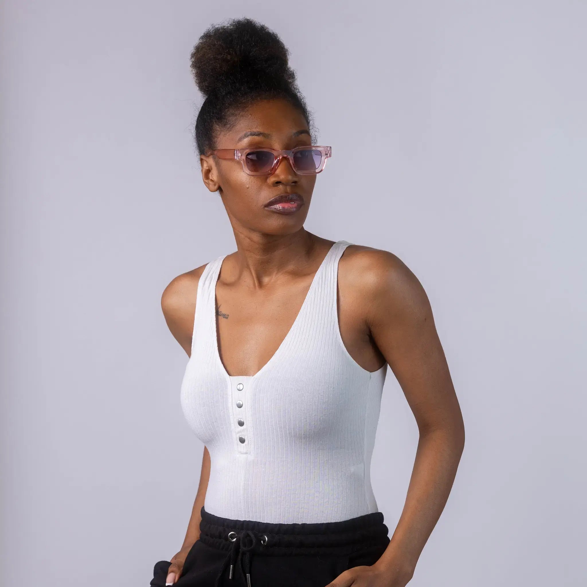 A female model wearing Exposure Sunglasses polarized sunglasses with pink frames and blue lenses, posing against a white background.