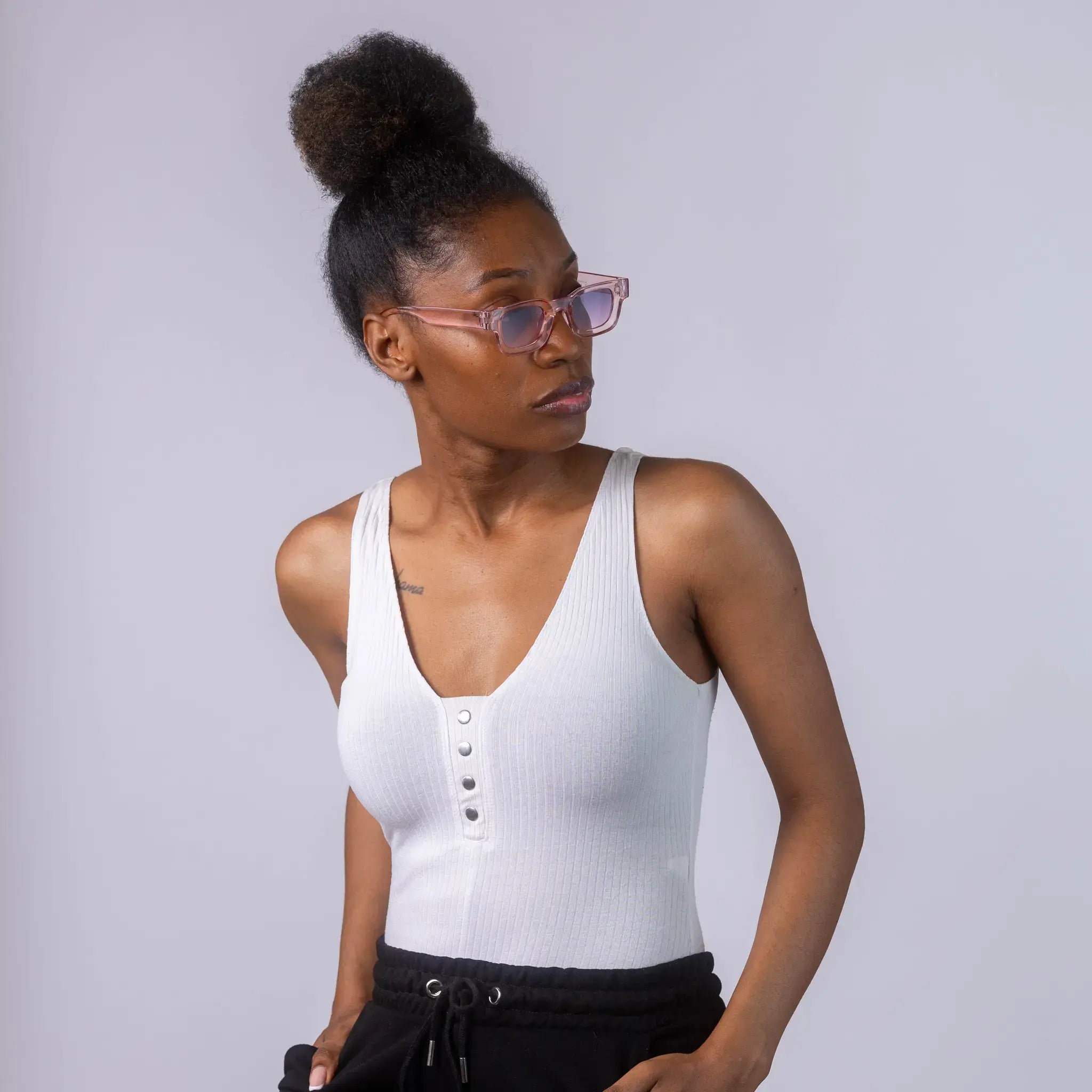 A female model wearing Exposure Sunglasses polarized sunglasses with pink frames and blue lenses, posing against a white background.