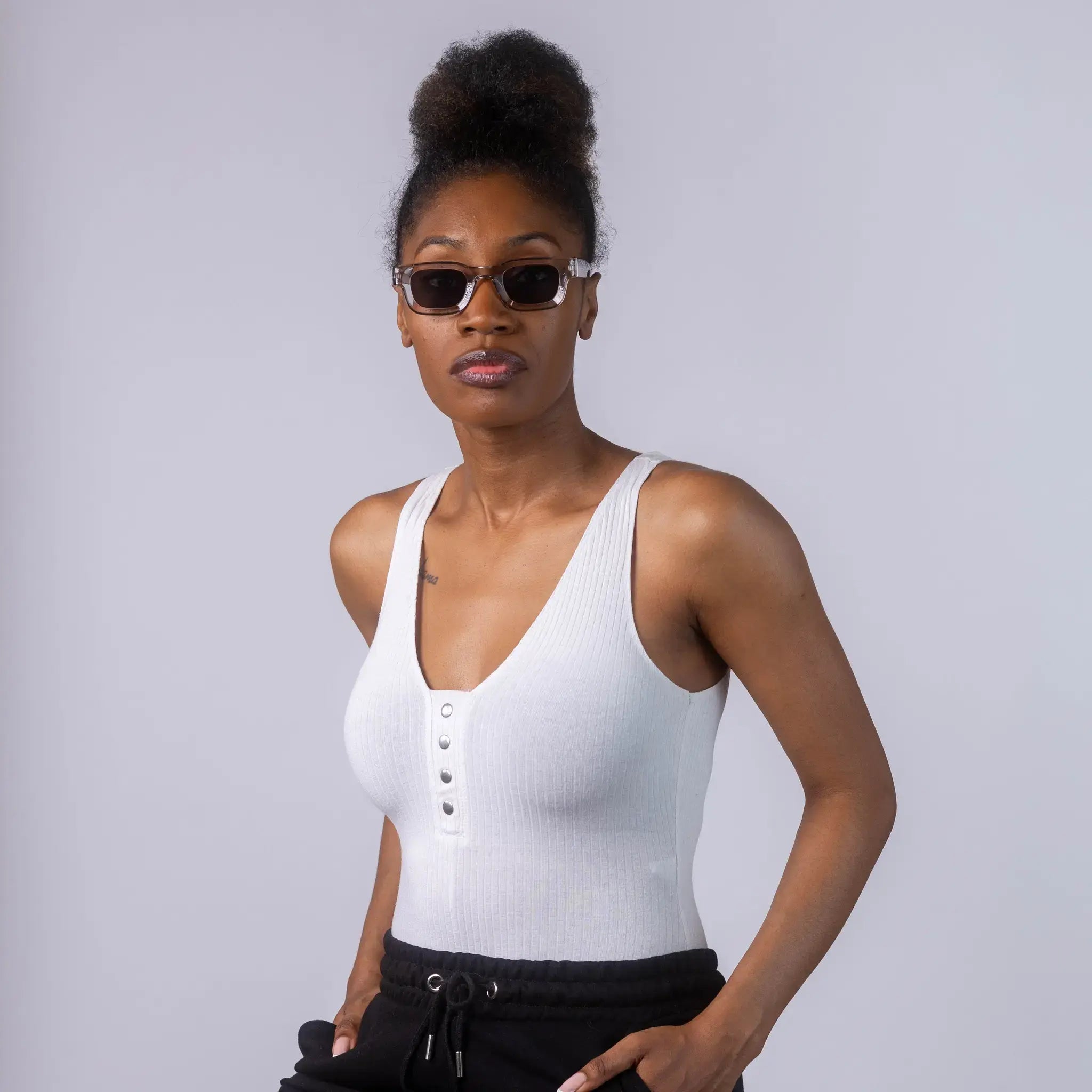 A female model wearing Exposure Sunglasses polarized sunglasses with silver frames and black lenses, posing against a white background.