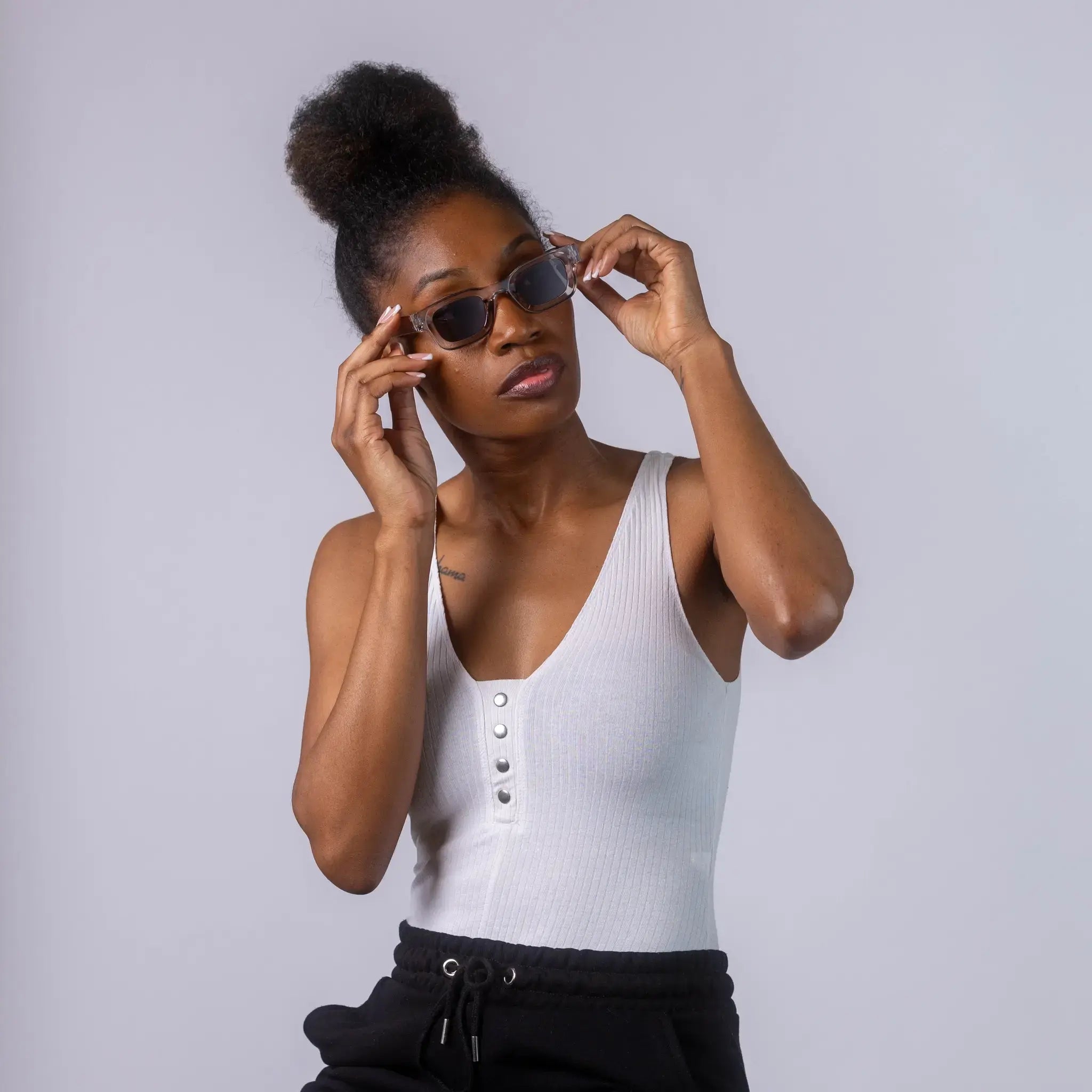 A female model wearing Exposure Sunglasses polarized sunglasses with silver frames and black lenses, posing against a white background.