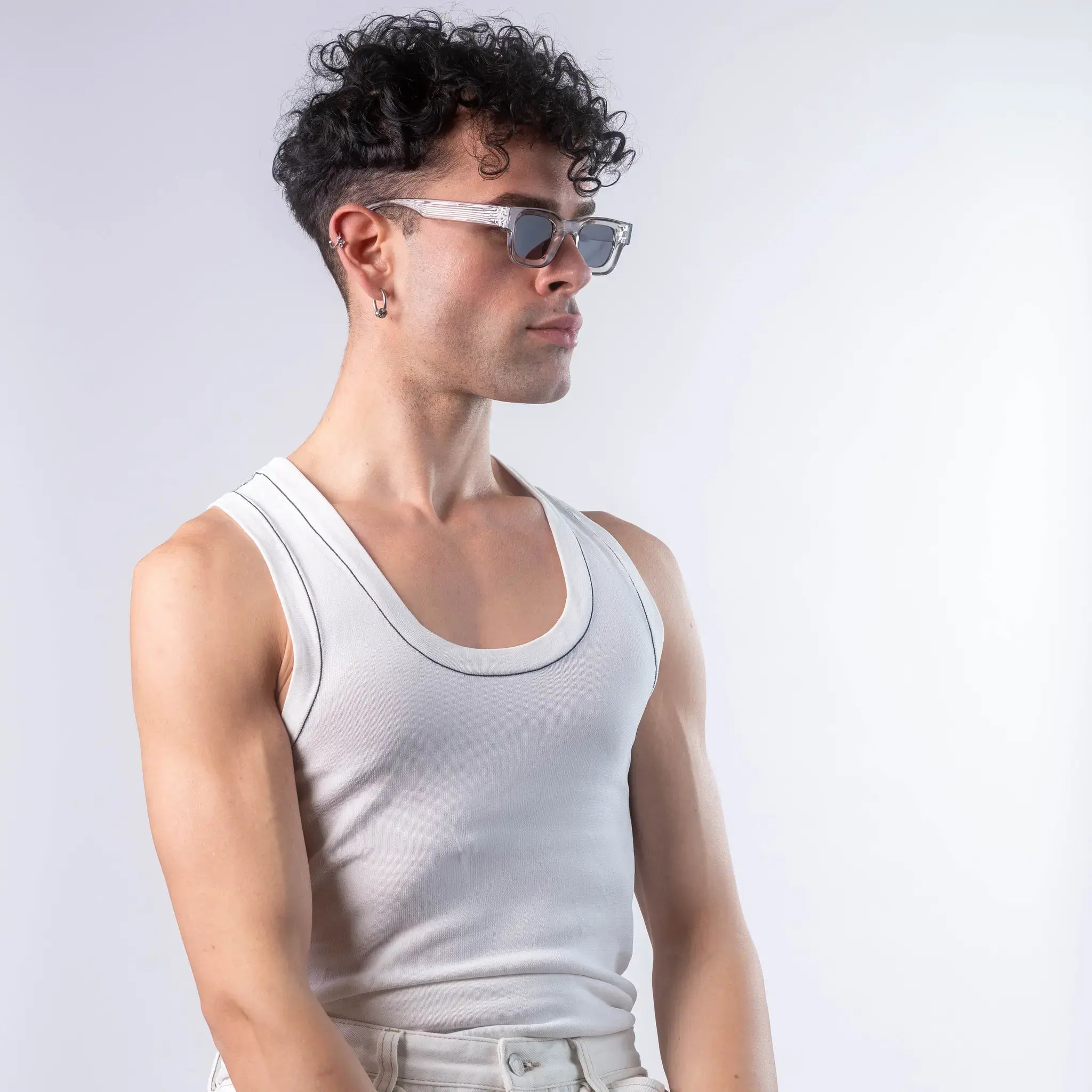 A male model wearing Exposure Sunglasses polarized sunglasses with silver frames and black lenses, posing against a white background.