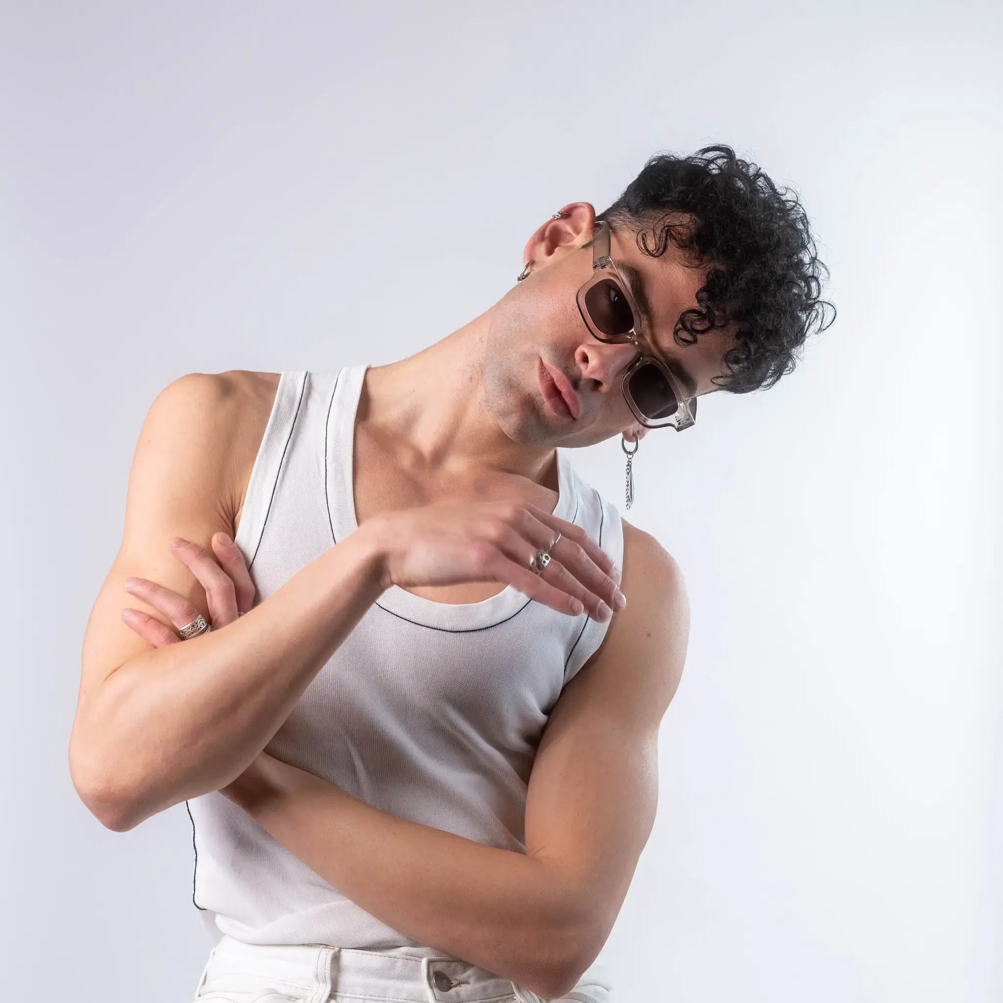 A male model wearing Exposure Sunglasses polarized sunglasses with silver frames and black lenses, posing against a white background.